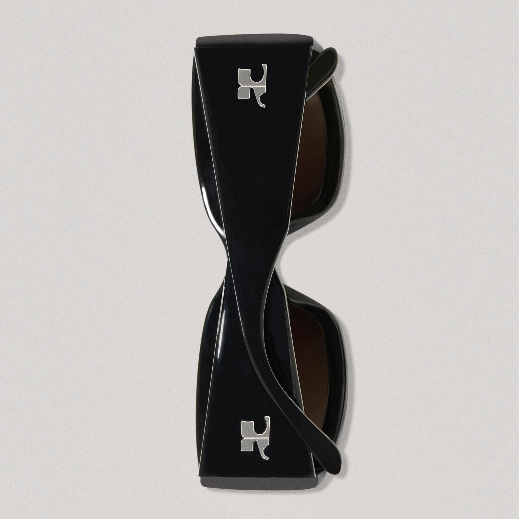 Elegant black sunglasses with Courrèges logo, perfect for fashion-forward ecommerce shoppers.