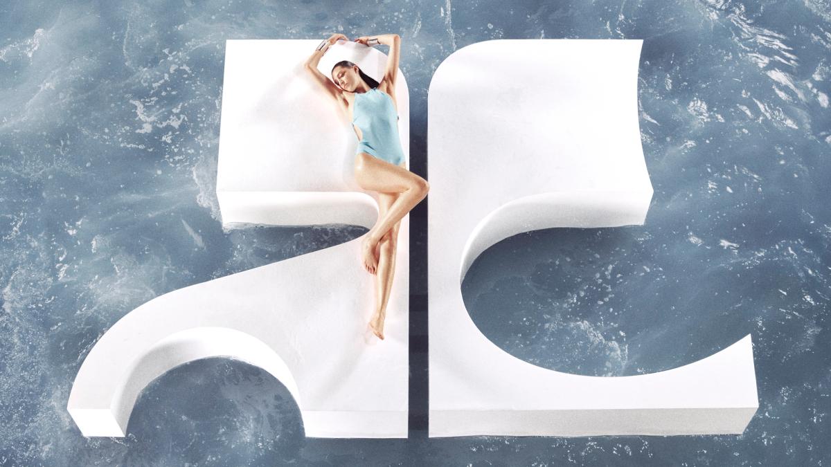 Elegant model wearing Courrèges swimwear, posed on a white sculpture over water, on an ecommerce site.