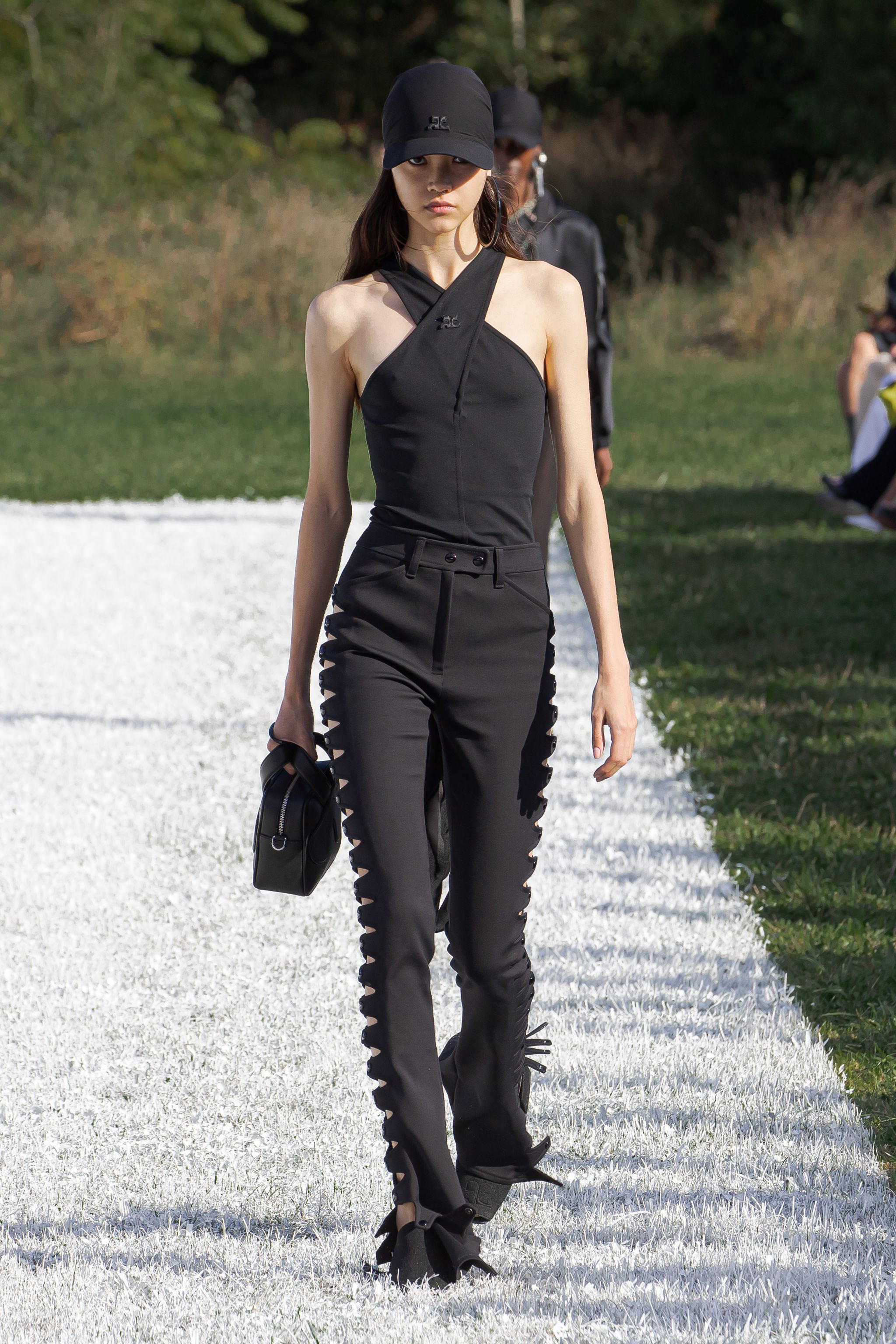 Elegant black outfit with unique cut-outs, showcased by a model for Courrèges on the runway.