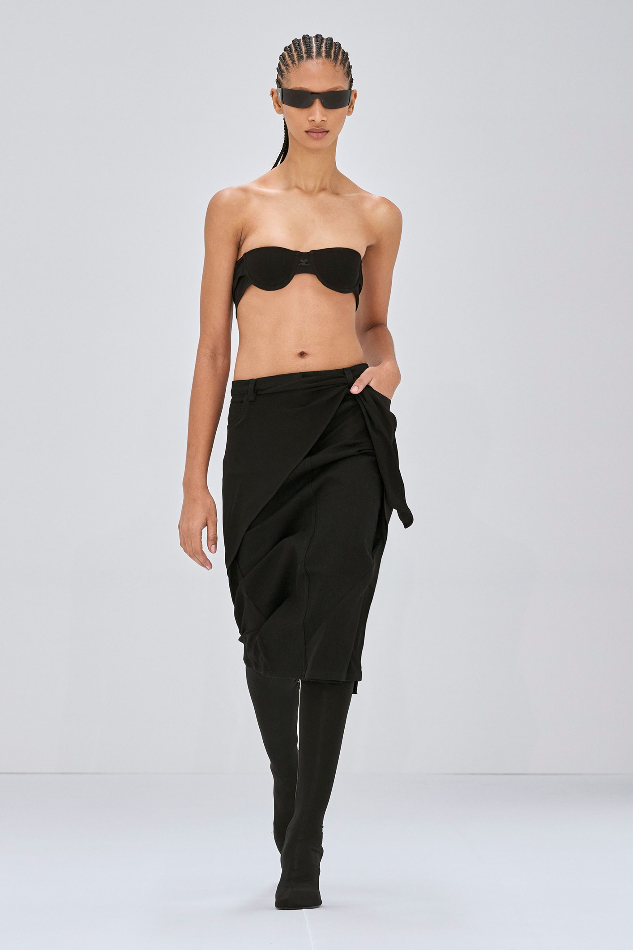 Elegant black fashion ensemble with a strapless top, long skirt, and futuristic sunglasses by Courrèges.