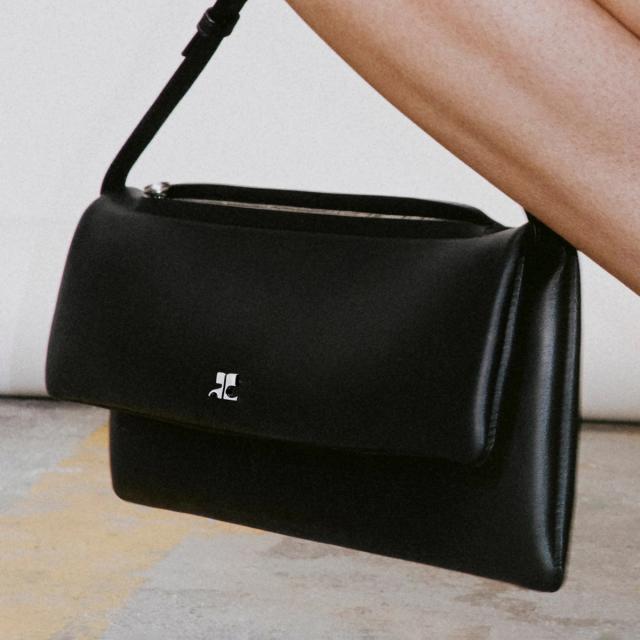 Elegant black leather handbag showcasing Courrèges branding, perfect for fashion enthusiasts.