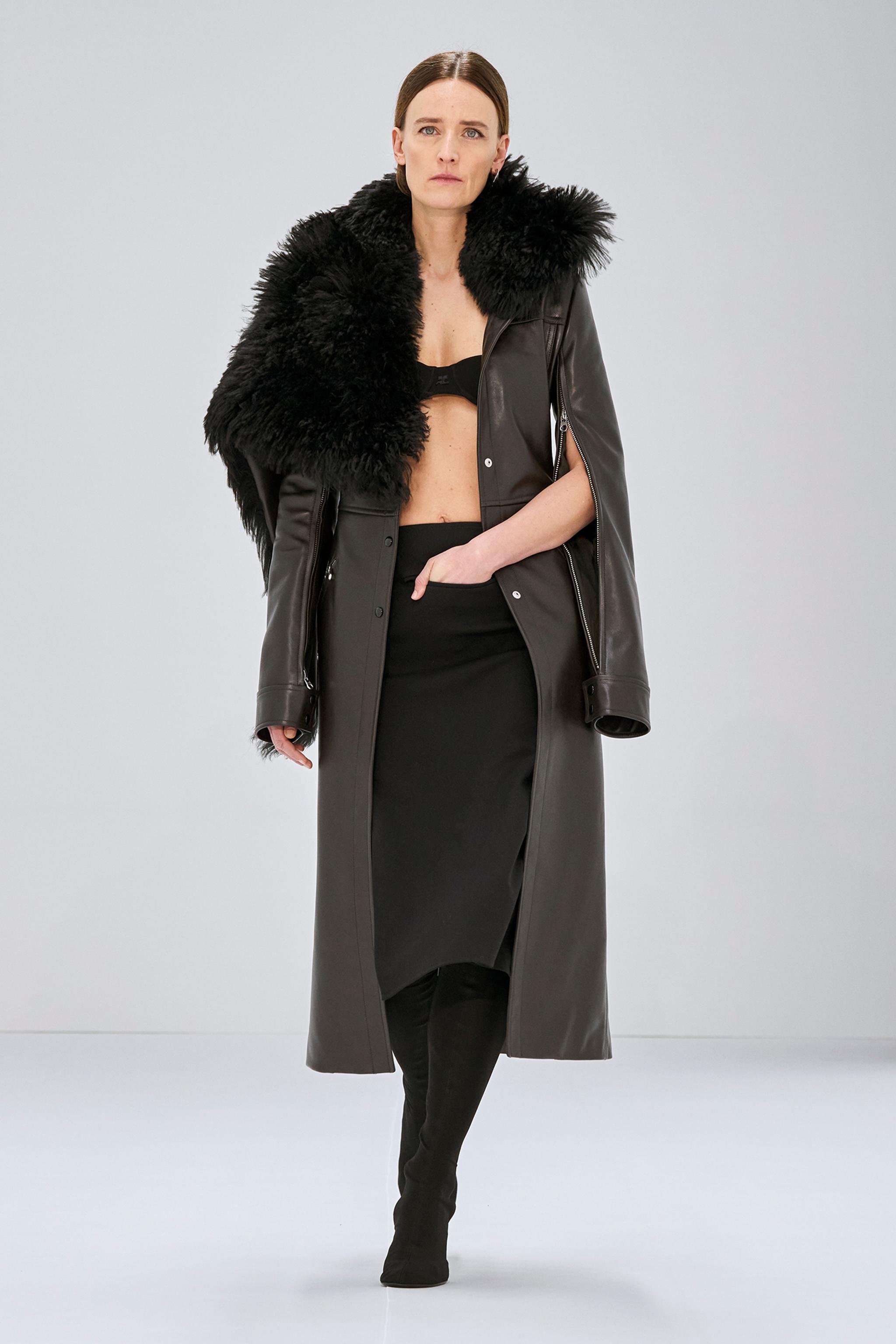 Allure élégante : manteau en cuir noir Courrèges avec col en fourrure porté par un mannequin.