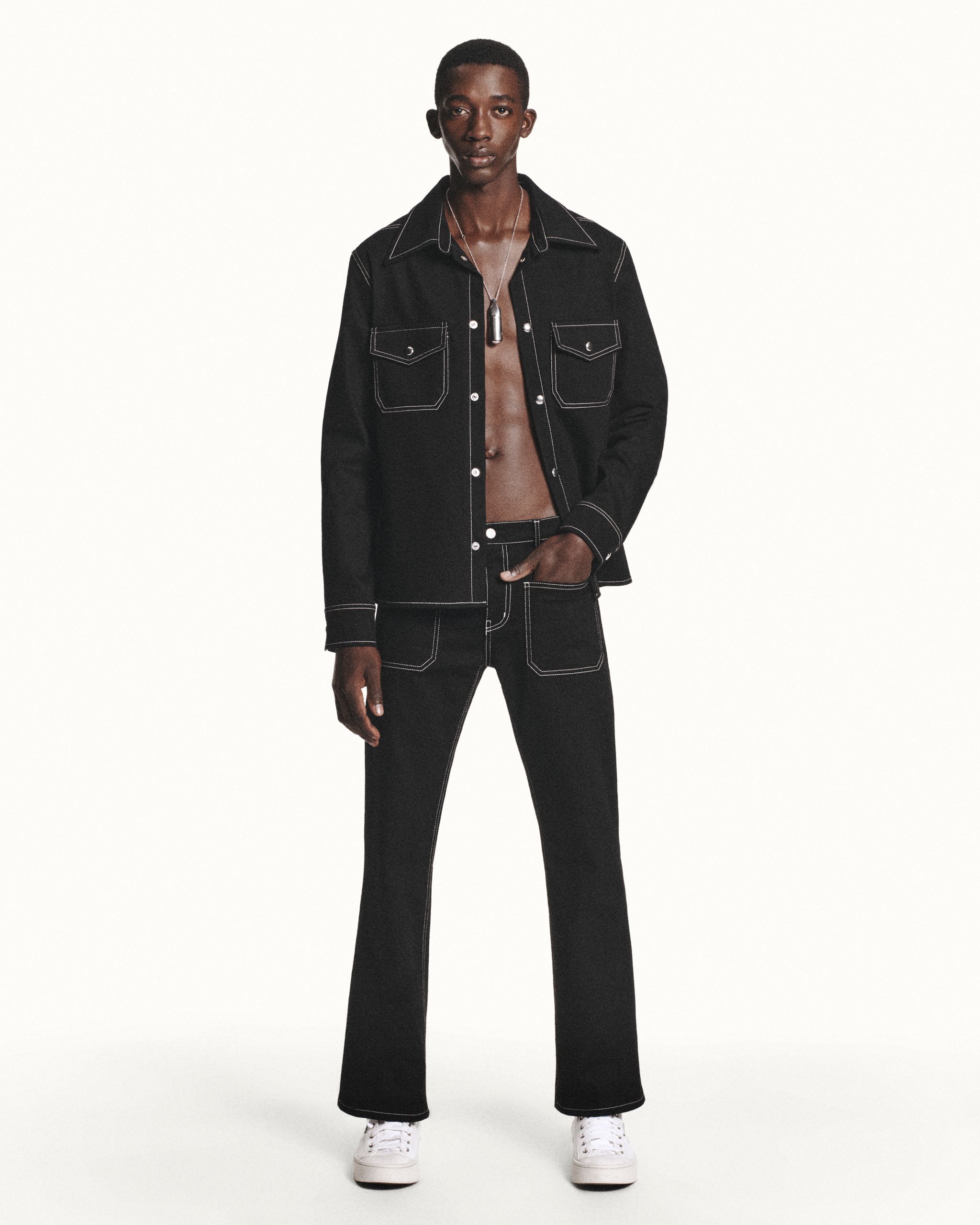 Elegant black denim jacket and jeans set showcasing Courrèges' modern fashion style.