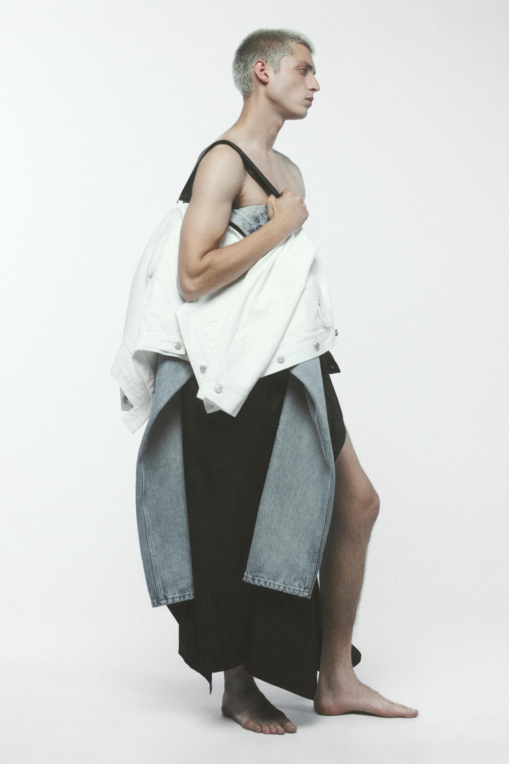 Elegant modern fashion look featuring denim, white jacket, and layered black and gray garments for Courrèges.