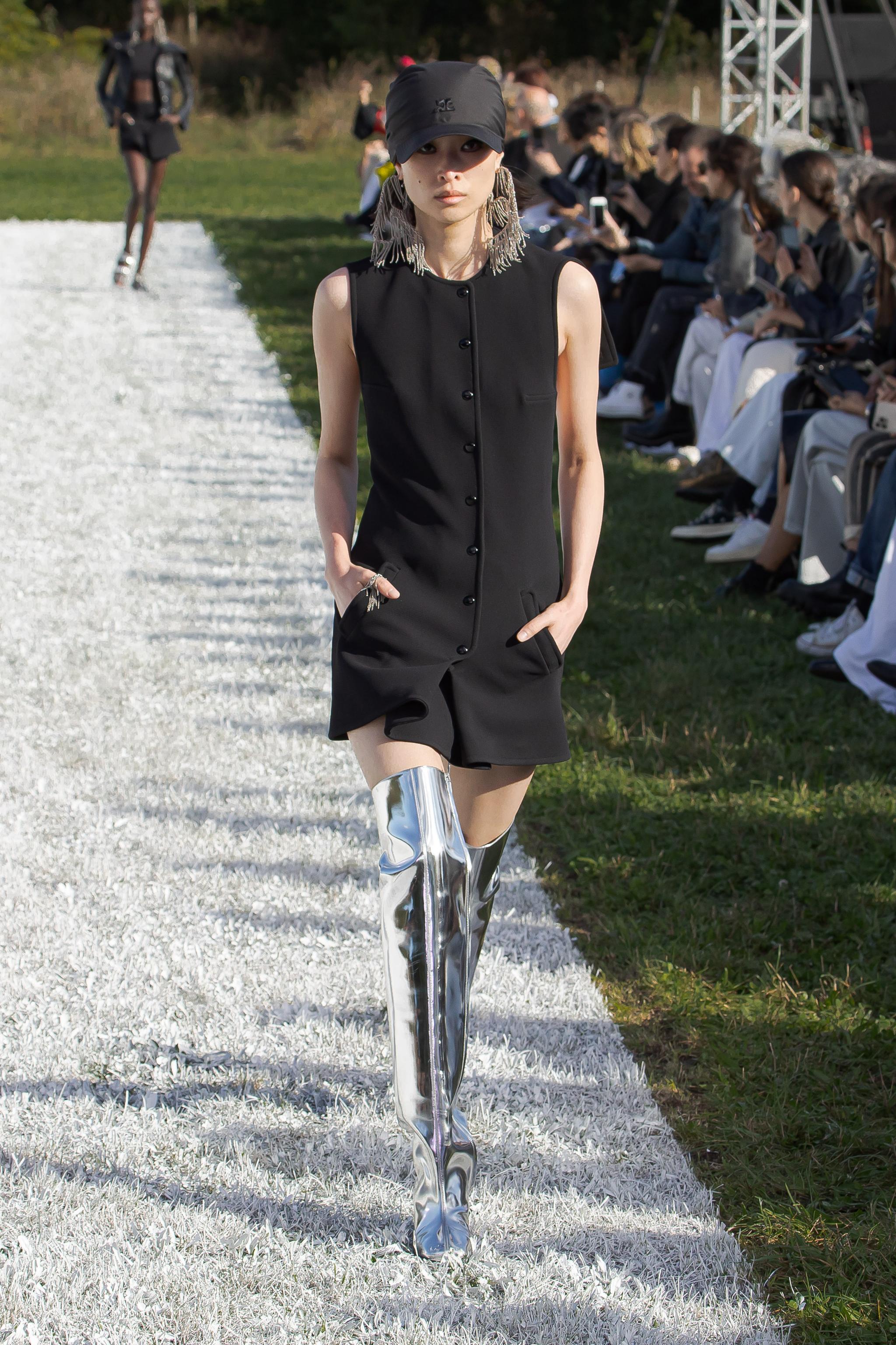 Elegant black sleeveless dress with buttons, styled with metallic thigh-high boots for Courrèges.