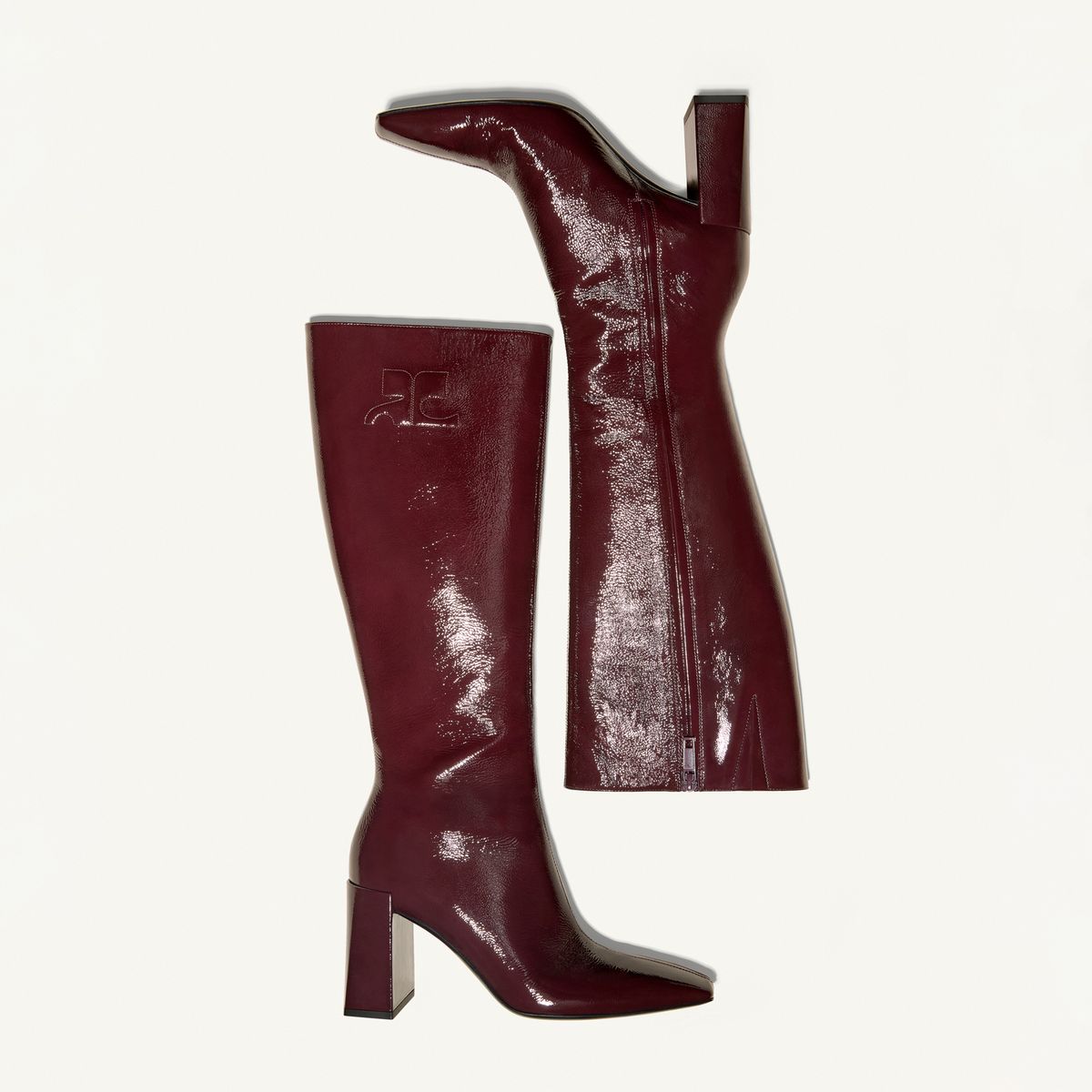 Elegant burgundy designer knee-high boots with pointed toes and high block heels, Courrèges fashion.