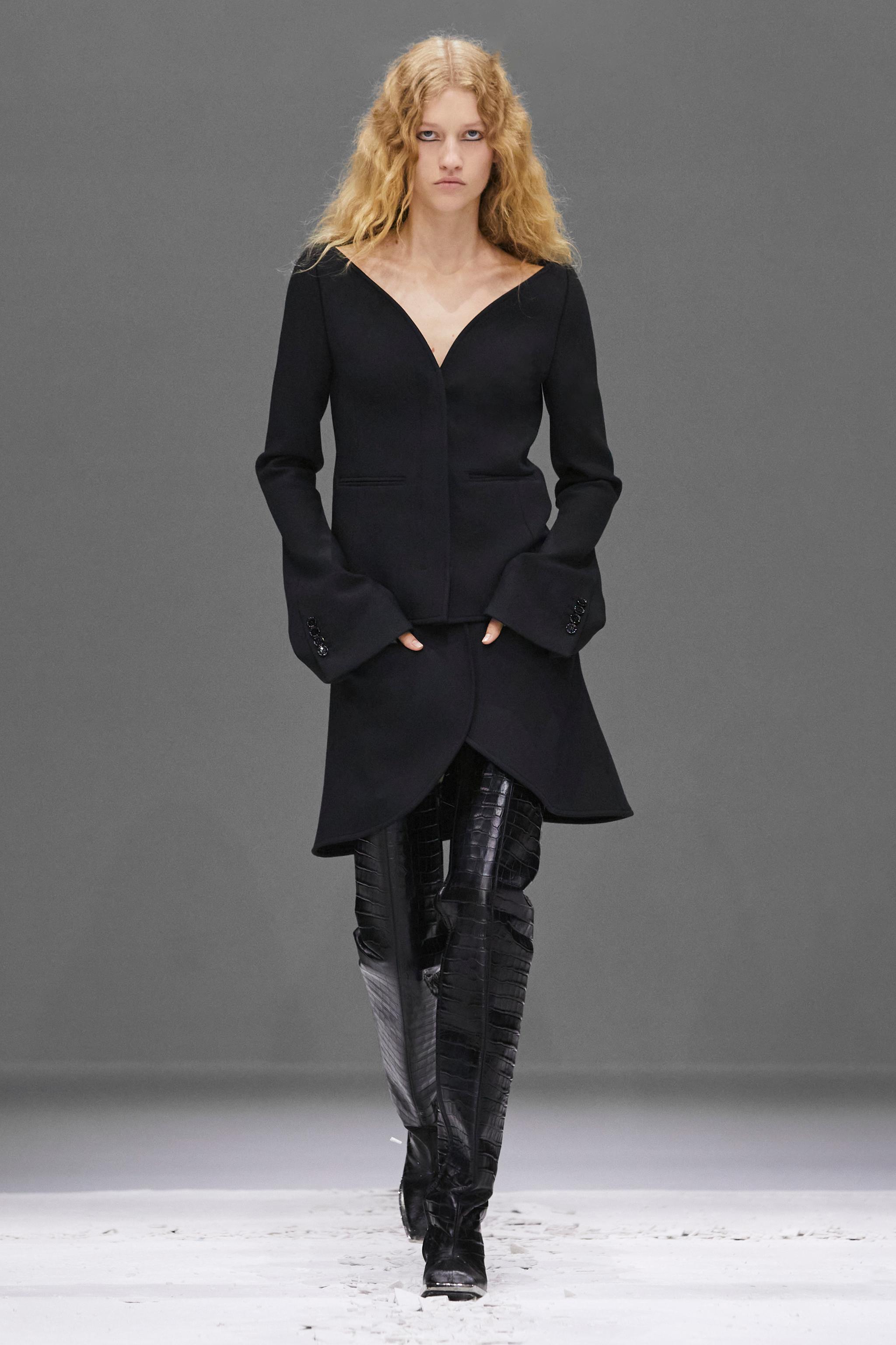 Elegant black tailored jacket paired with matching skirt and stylish knee-high leather boots for Courrèges.