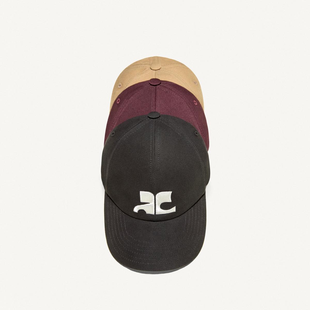 Elegant black Courrèges baseball cap with white logo, perfect for stylish casual wear.