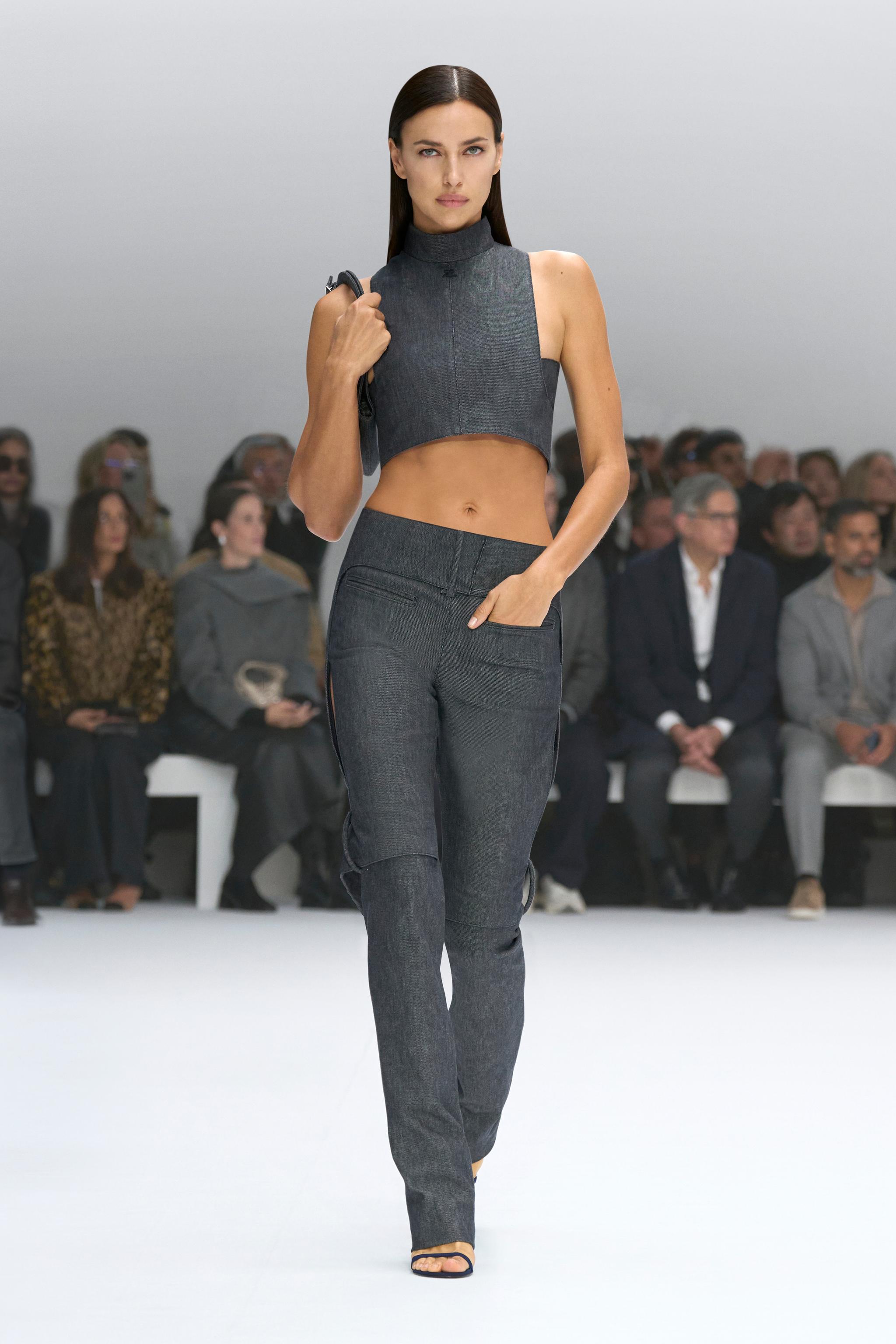 Elegant model wearing Courrèges denim crop top and trousers on the runway at a fashion show.