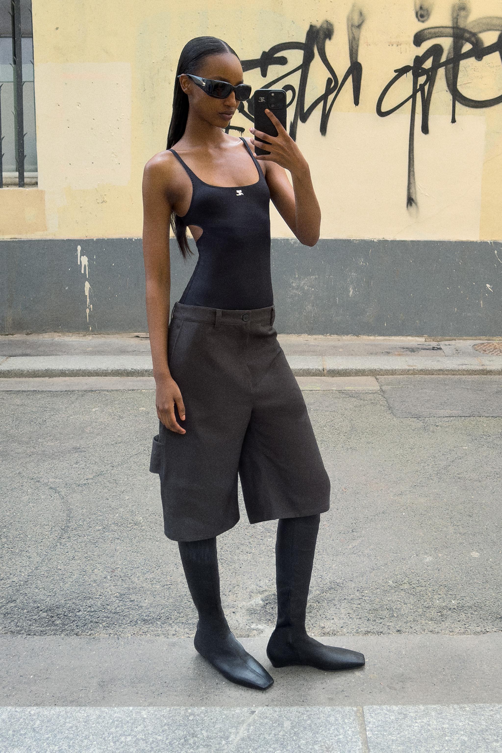 Elegant black fashion outfit featuring a sleek top, oversized shorts, and stylish accessories for Courrèges.