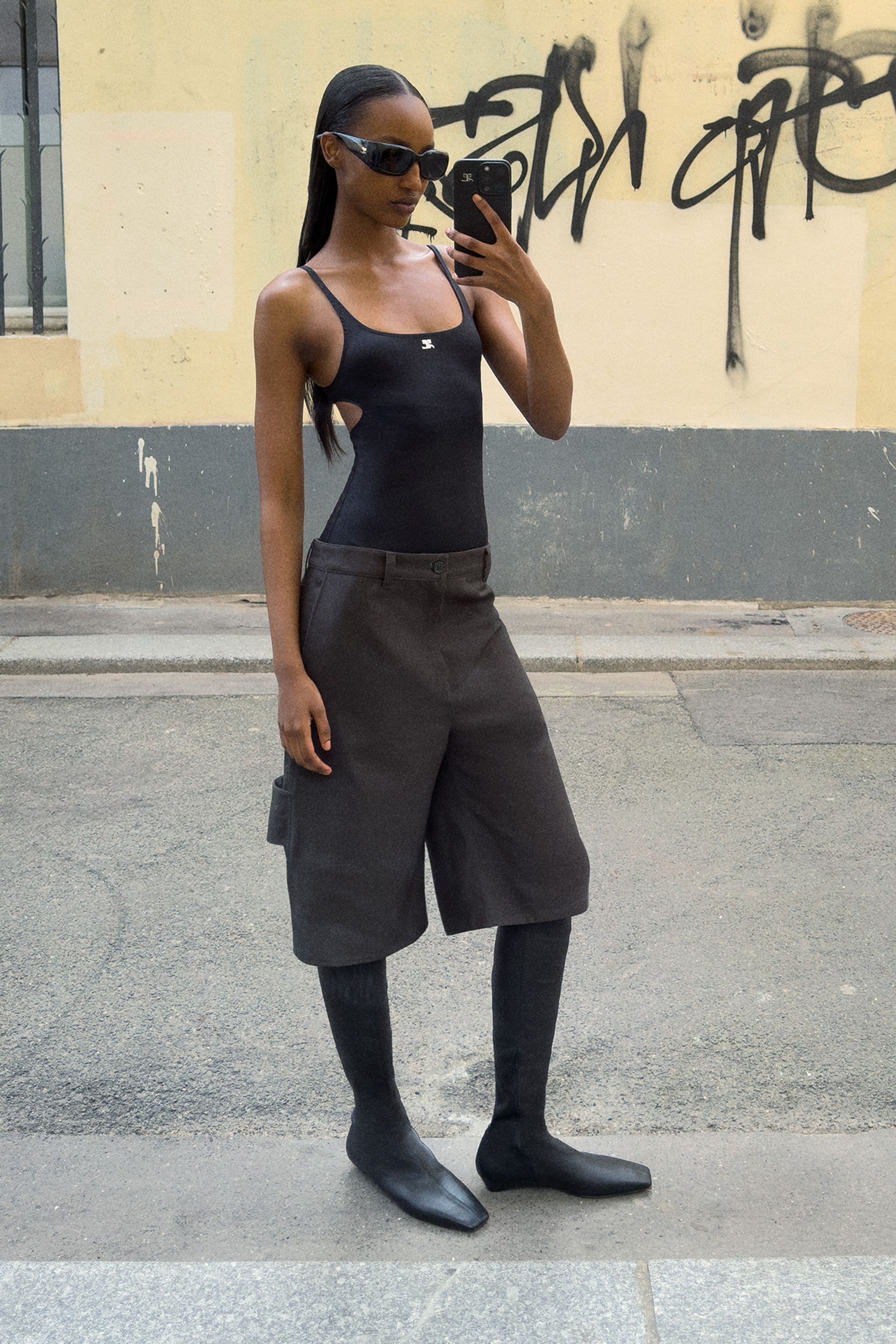 Elegant all-black Courrèges outfit featuring a sleek bodysuit and stylish boots.