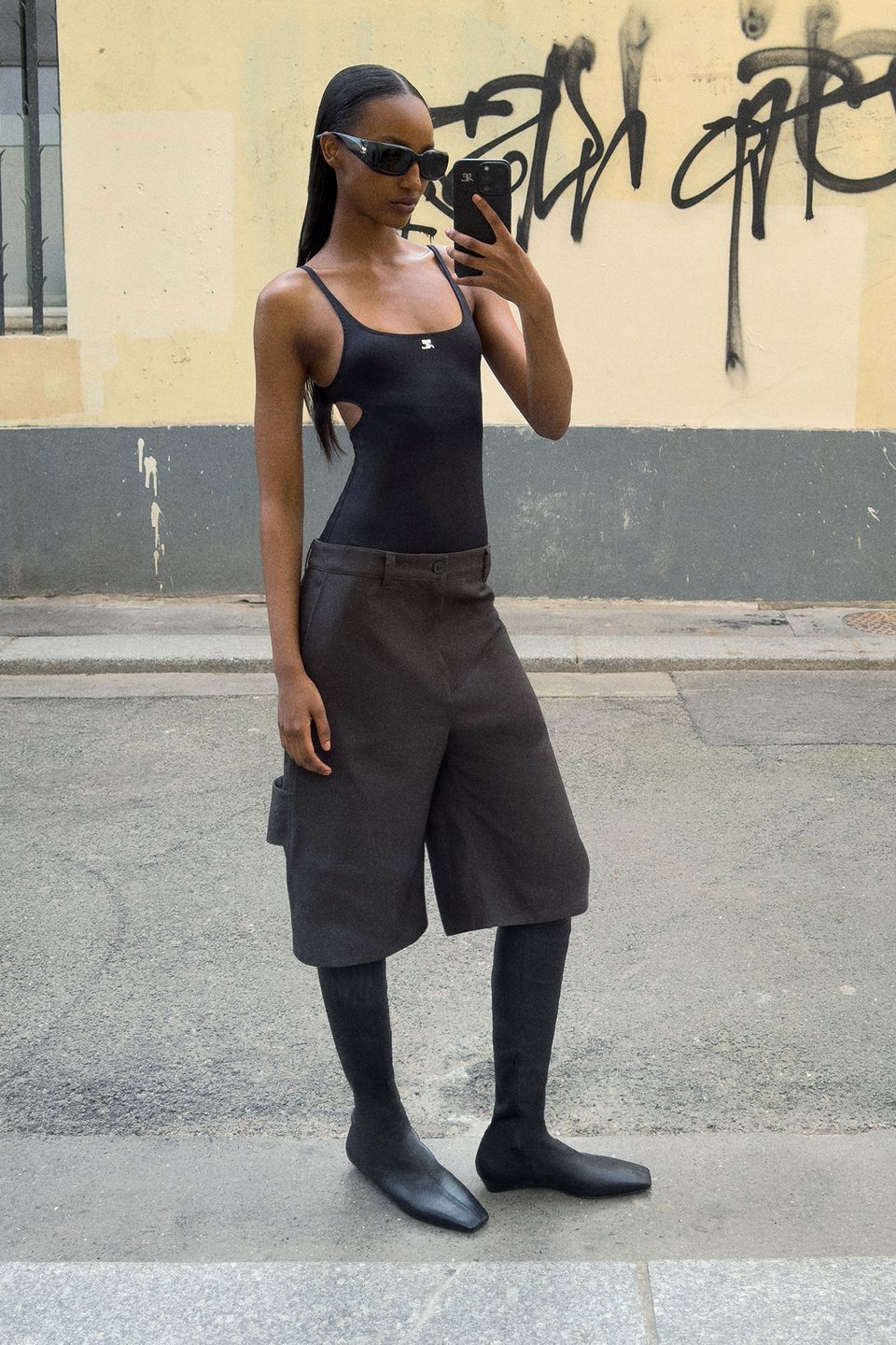 Elegant all-black Courrèges outfit featuring a sleek bodysuit and stylish boots.