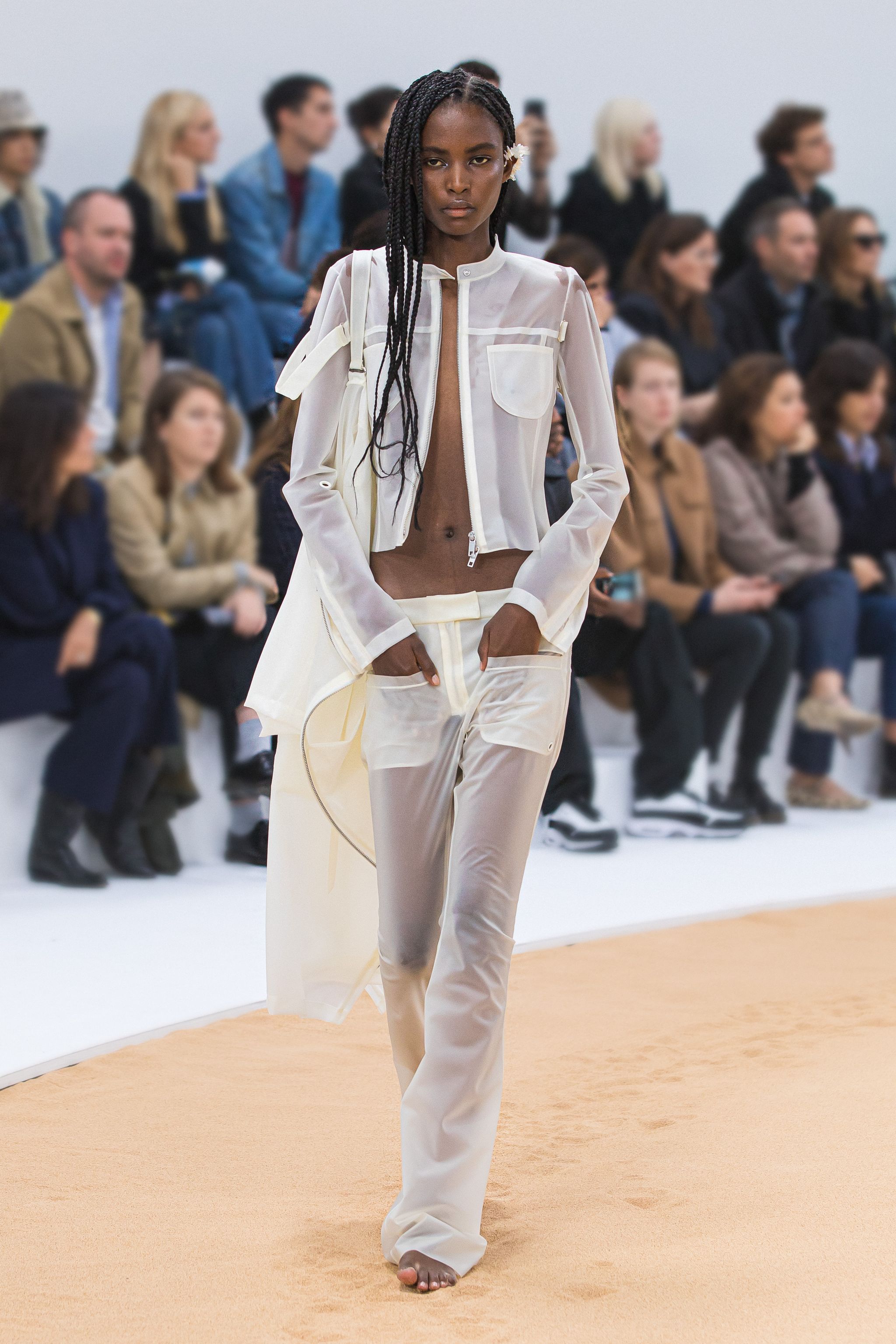 Elegant female runway model wearing Courrèges designer neutral-toned casual-chic outfit.
