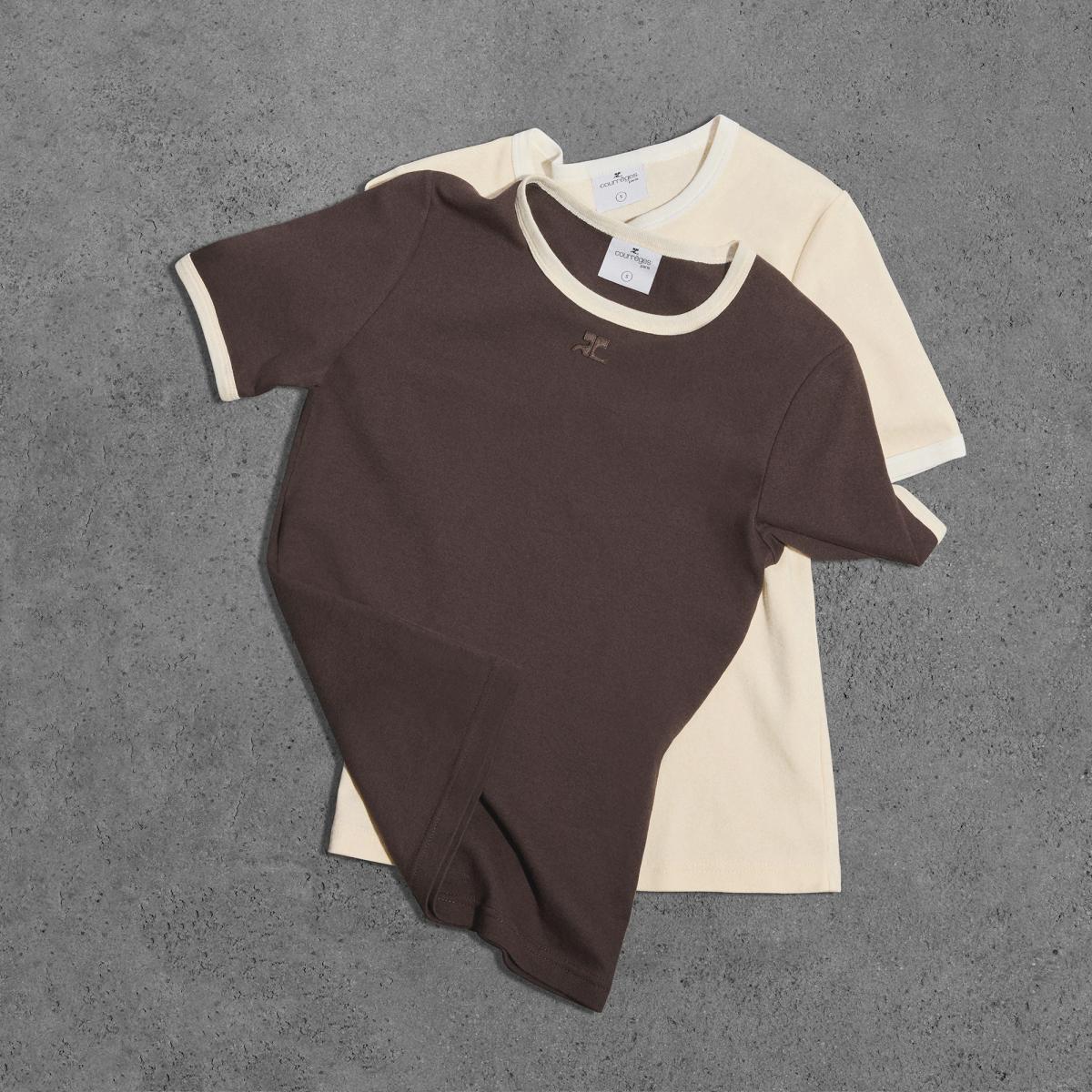 Elegant Courrèges fashion T-shirts on a textured gray background, stylish and minimalist.