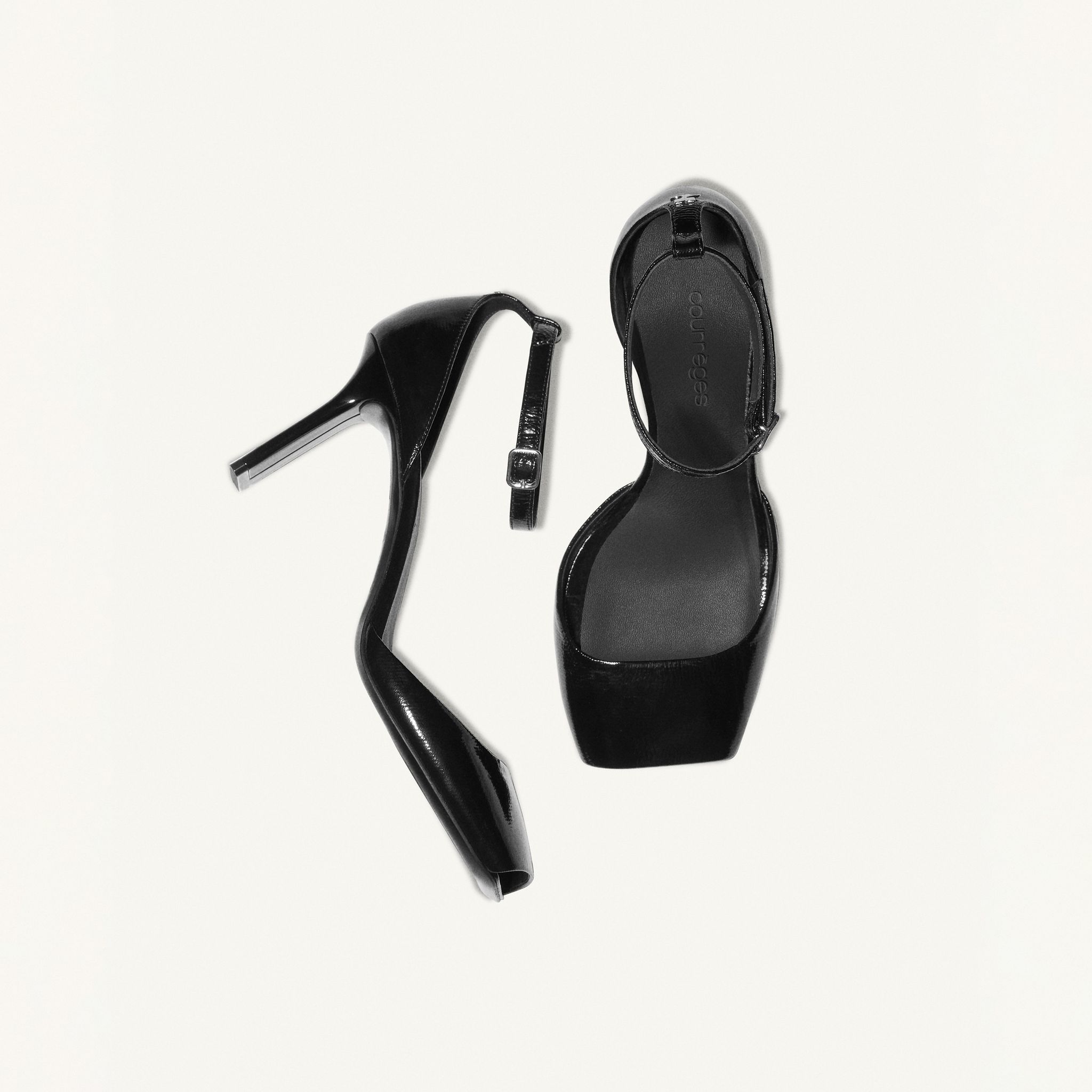 Elegant black high-heeled sandal with ankle strap, showcased on an ecommerce site for Courrèges.