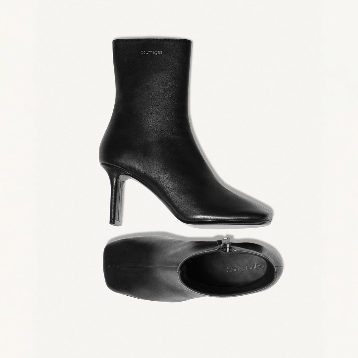 Elegant black leather ankle boots with high heels, designed by Courrèges for modern fashion.