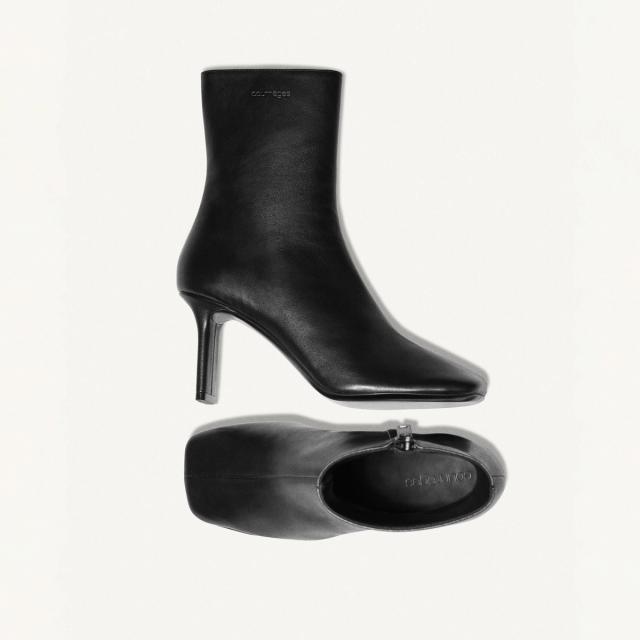 Elegant black leather high-heel ankle boots by Courrèges, showcased on a white background.