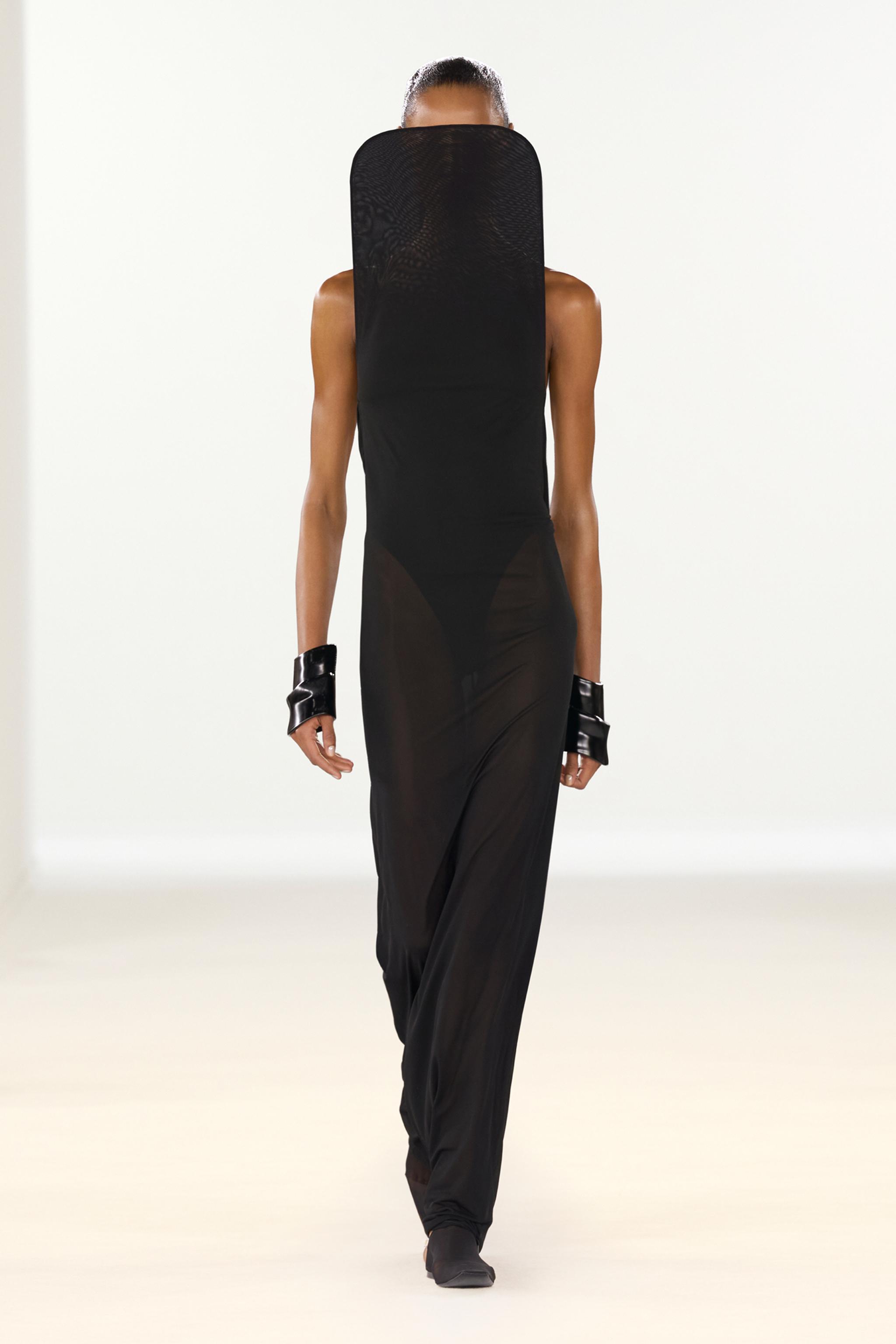 Elegant black dress by Courrèges featuring unique asymmetrical design on a fashion runway.