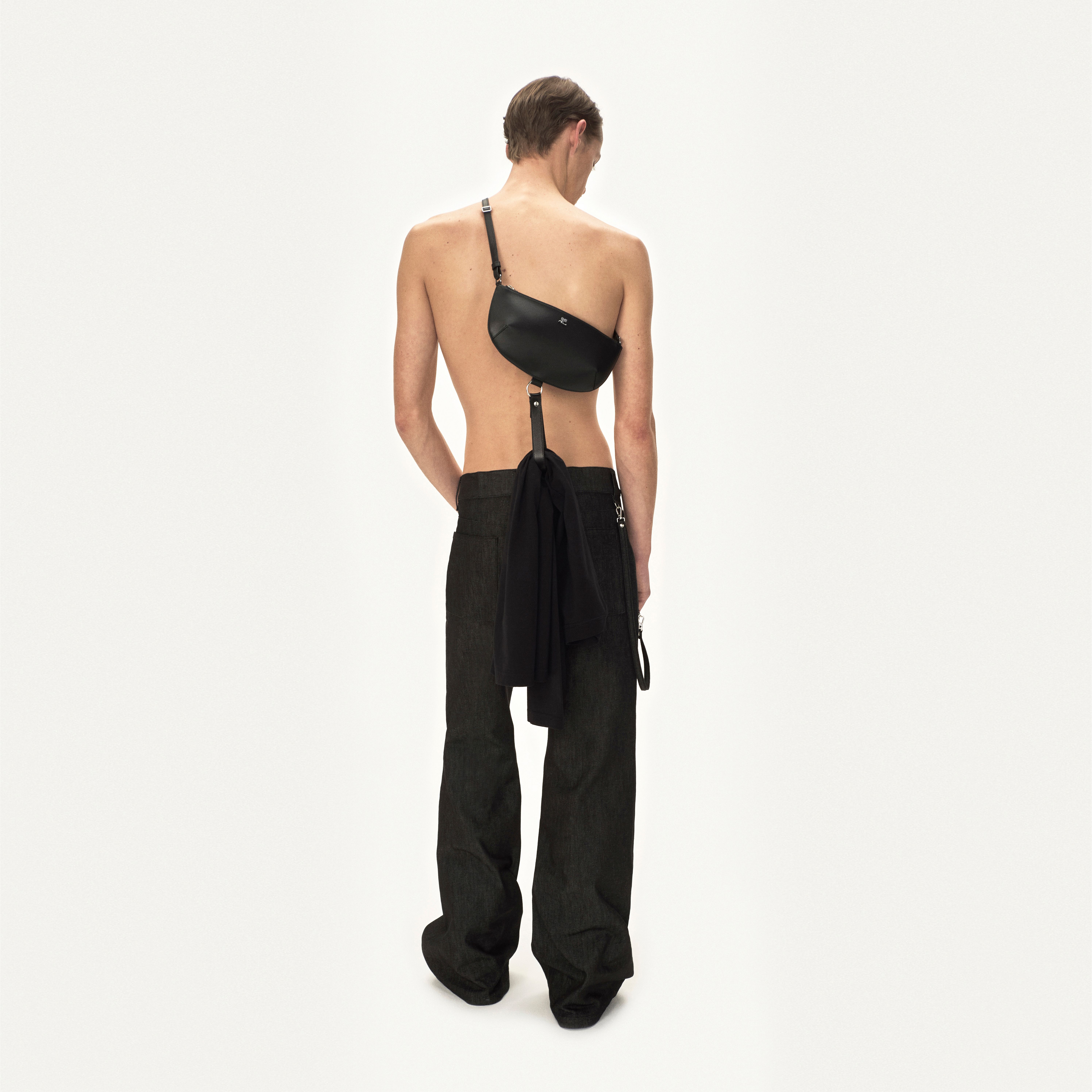 Elegant black crossbody bag with adjustable strap, part of Courrèges' contemporary fashion collection.