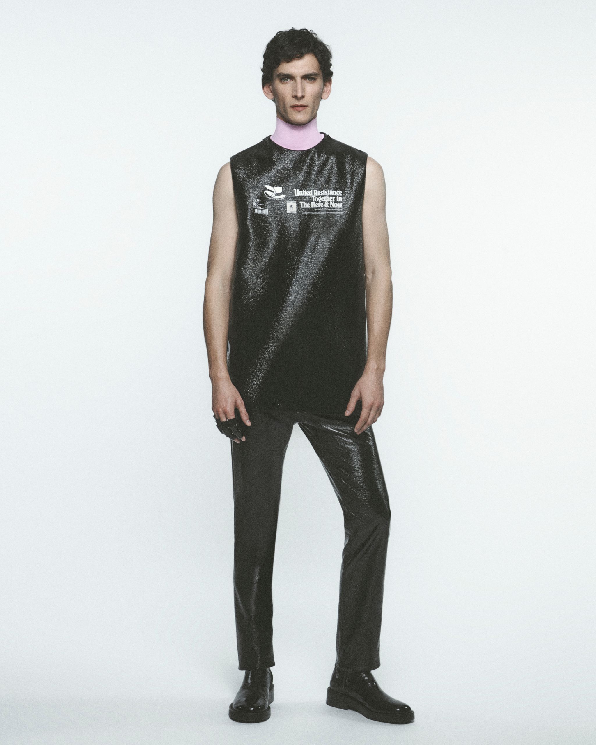 Modèle masculin élégant portant un vêtement Courrèges futuriste avec détails métalliques.