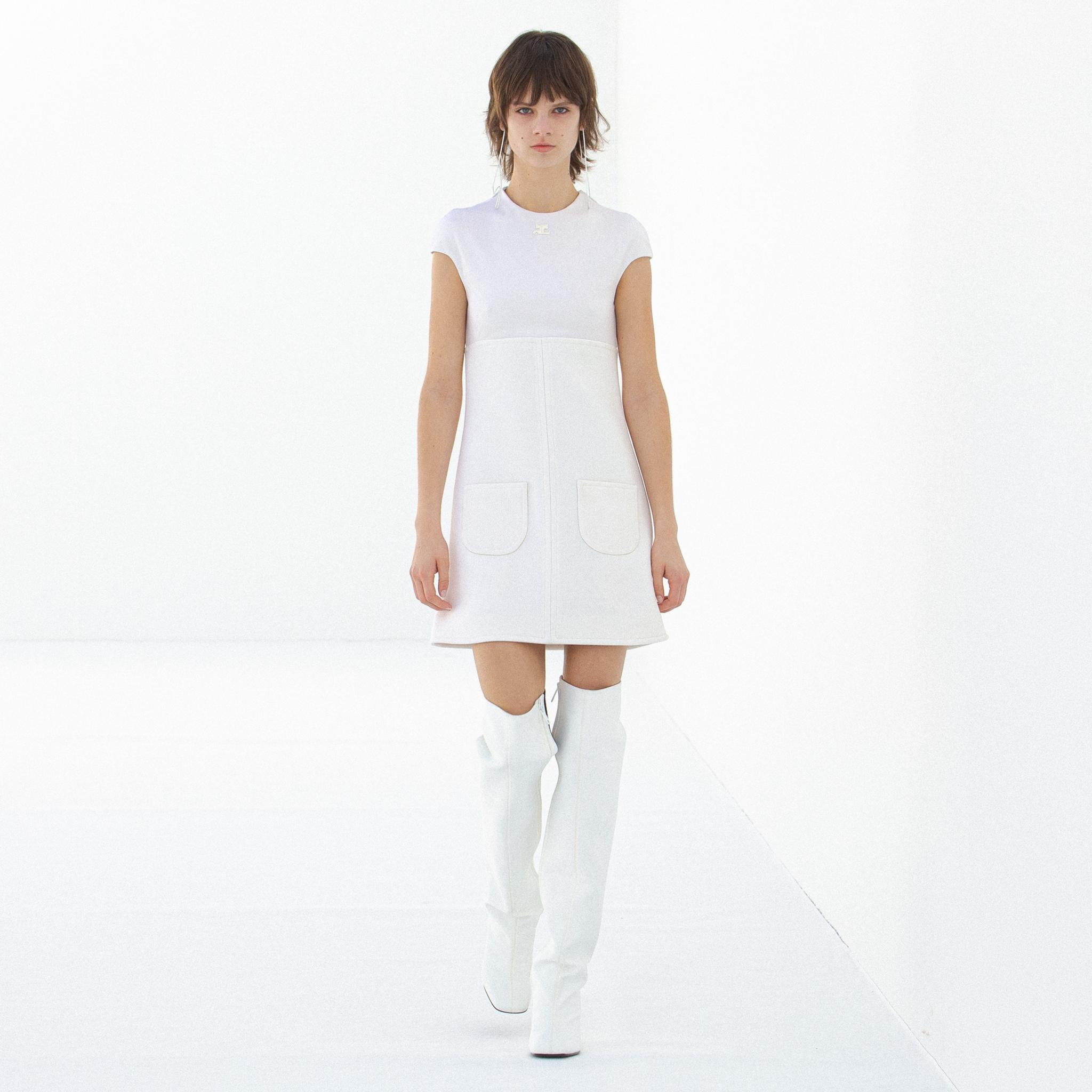 Robe blanche élégante avec poches appliquées et cuissardes blanches, présentée par Courrèges sur un site e-commerce.