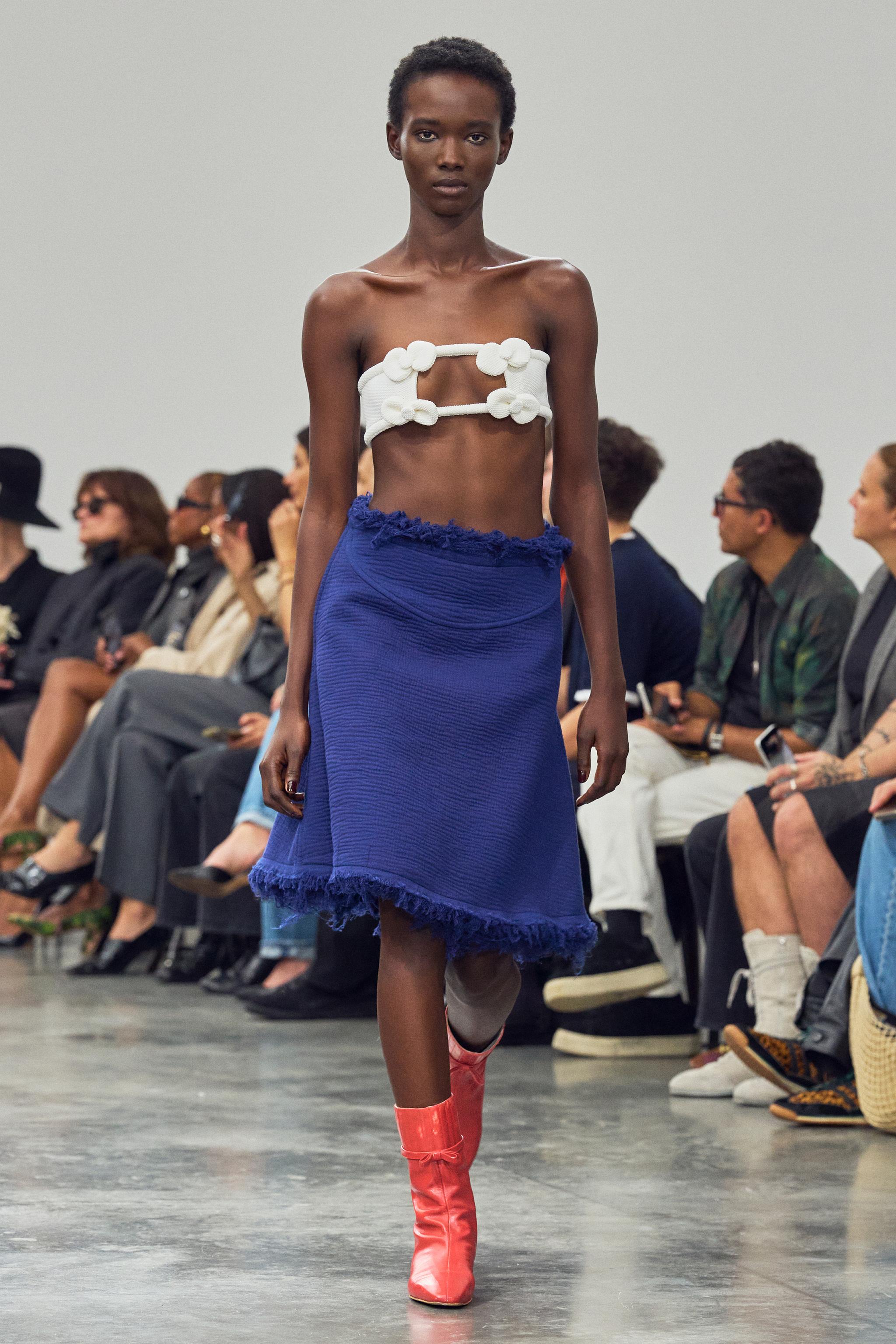Elegant high-fashion runway model wearing Courrèges contemporary clothing with vibrant accessories.