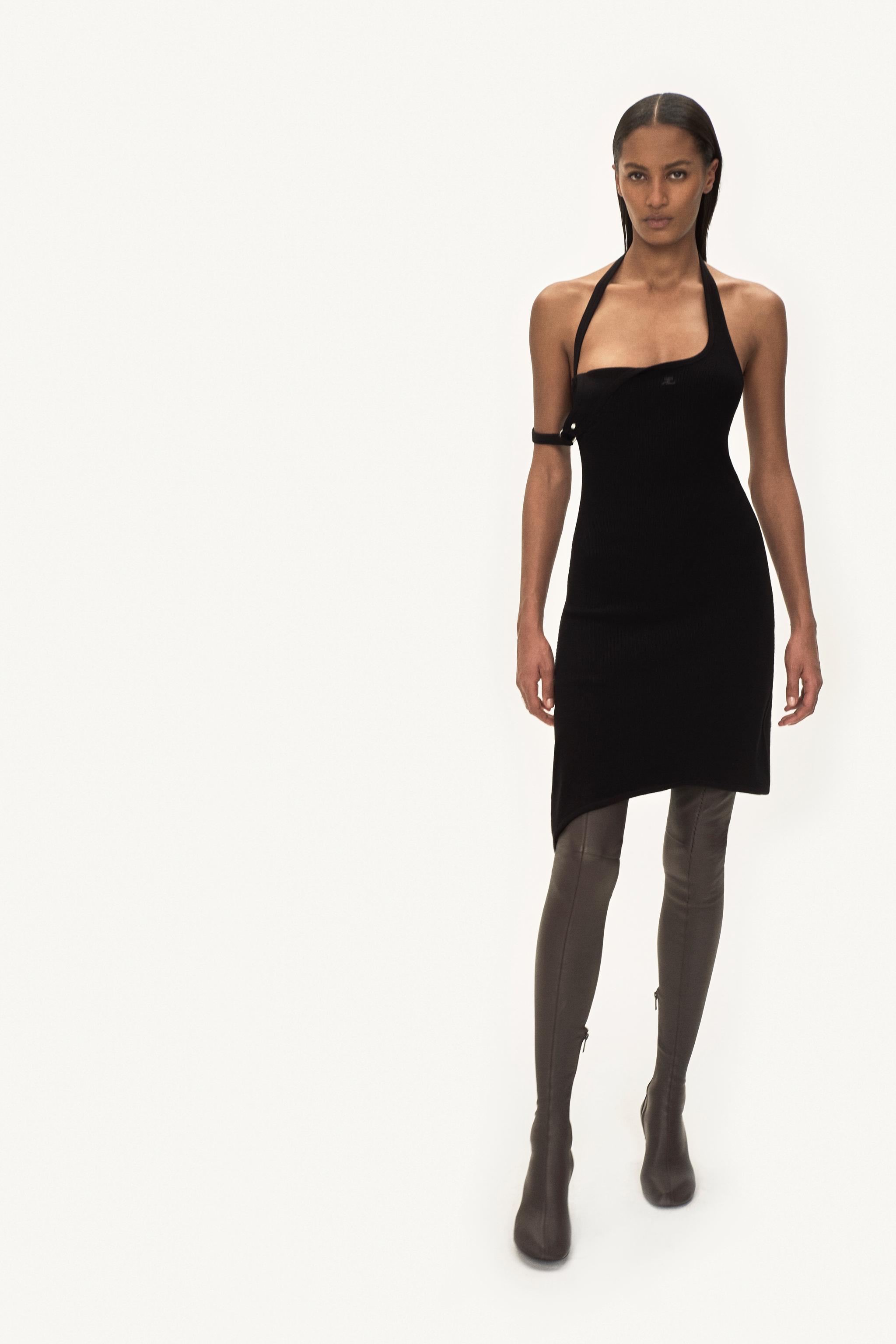 Robe noire élégante avec détails d'attache uniques, portée par un mannequin pour Courrèges.