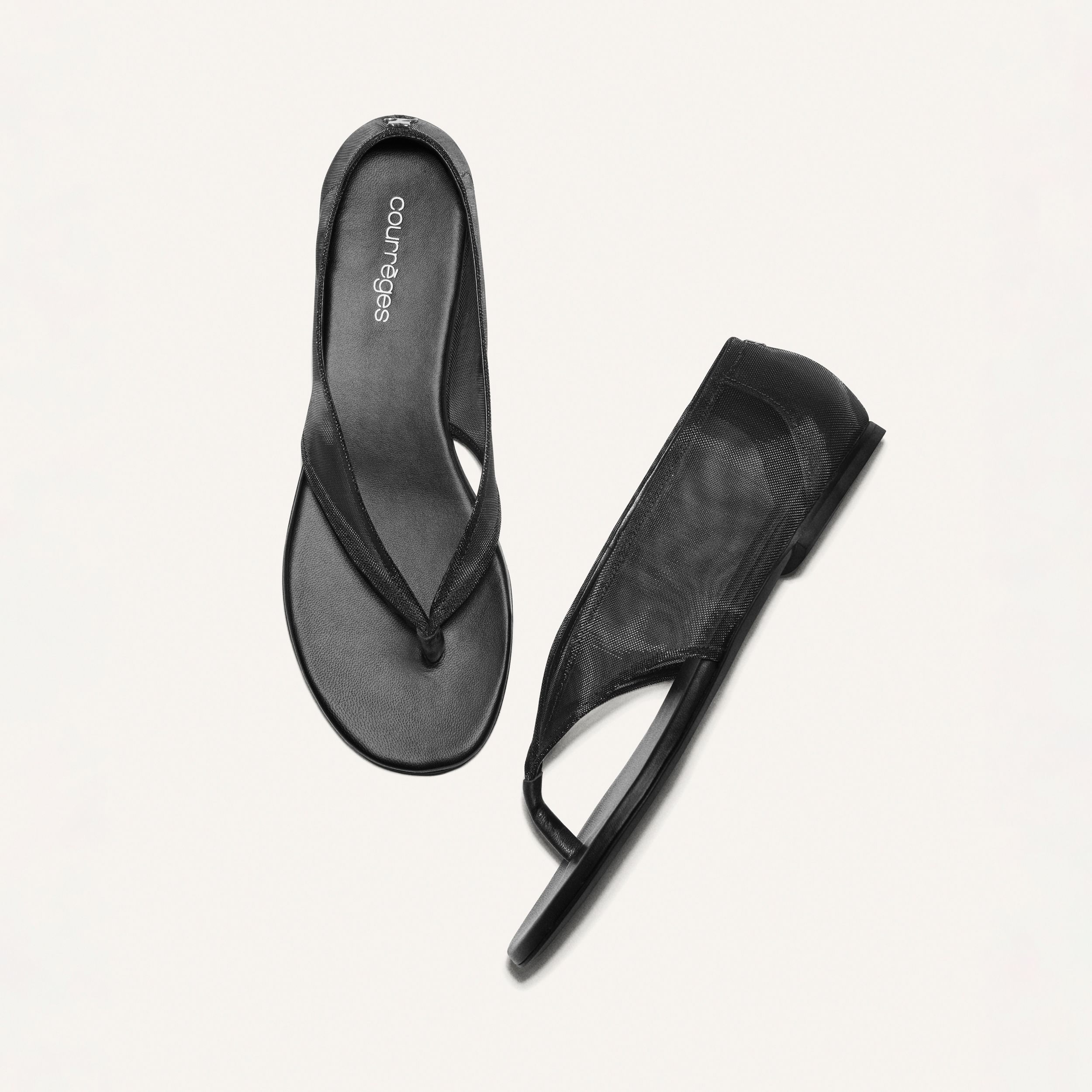 Elegant black sandals by Courrèges featured on an ecommerce fashion website.