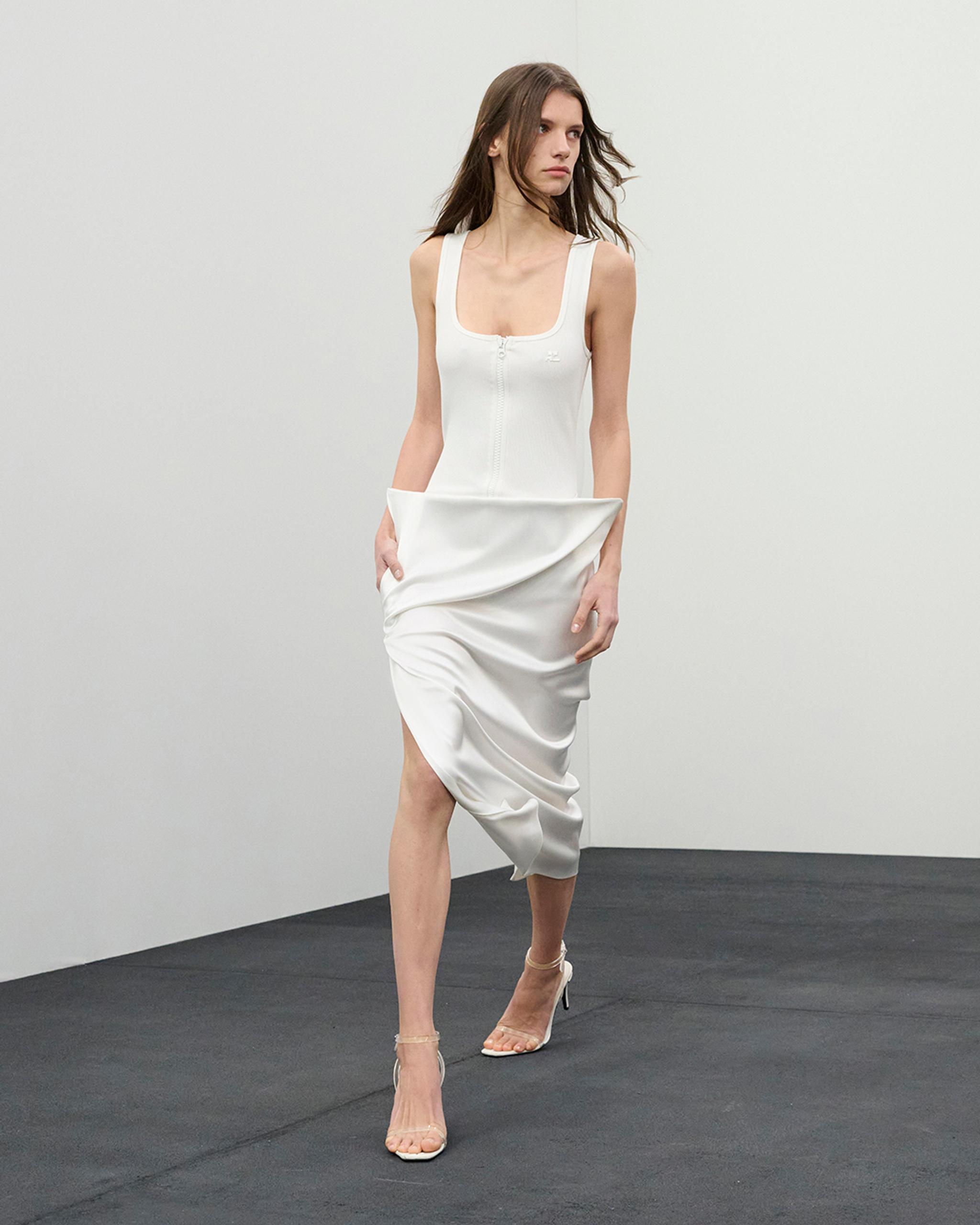 Elegant white dress with a fitted top and draped skirt, perfect for Courrèges fashion.