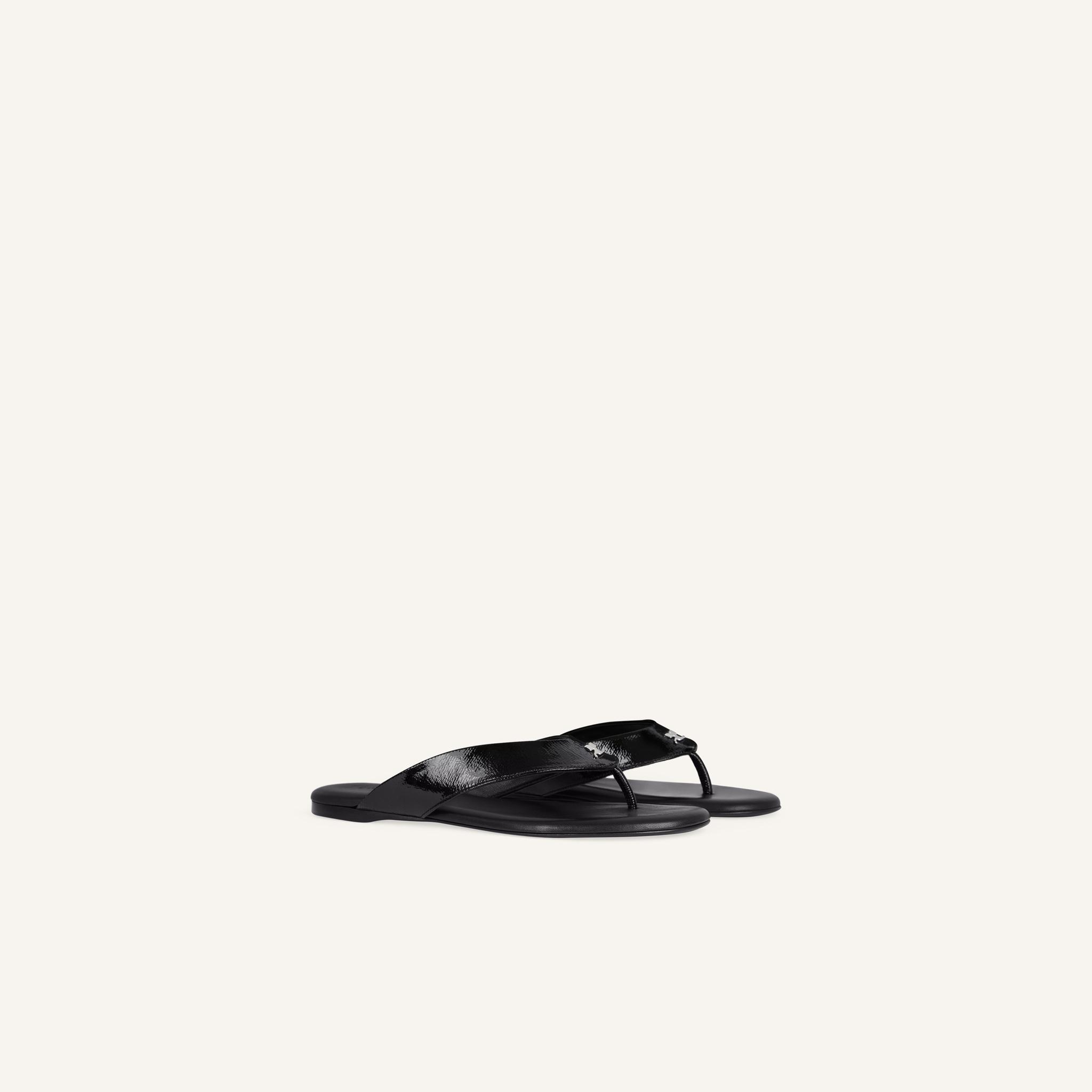 Elegant black Courrèges flip-flops with minimalist design, perfect for stylish summer wear.