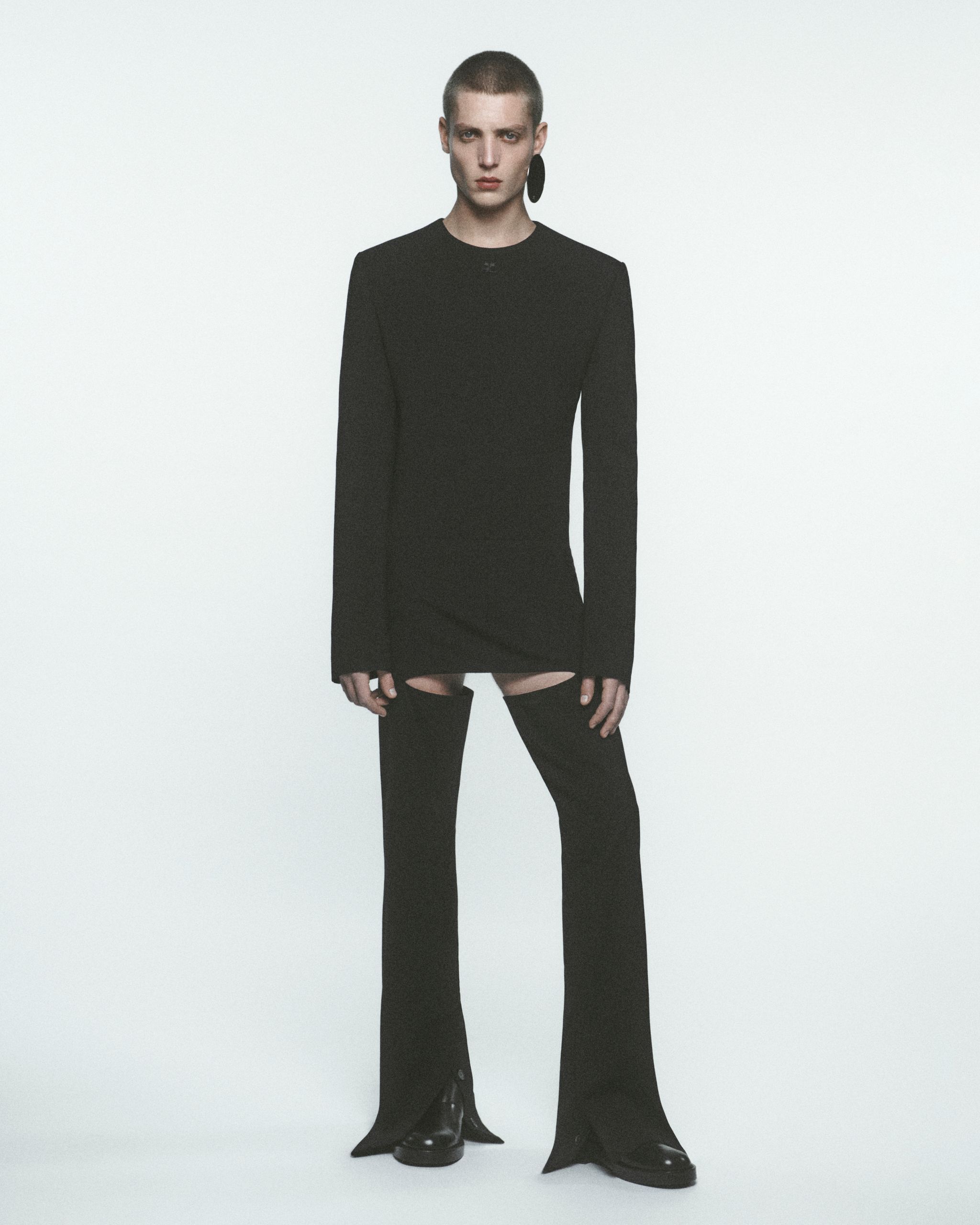 Modèle féminin élégant en tenue Courrèges noire, affichant un style moderne minimaliste.