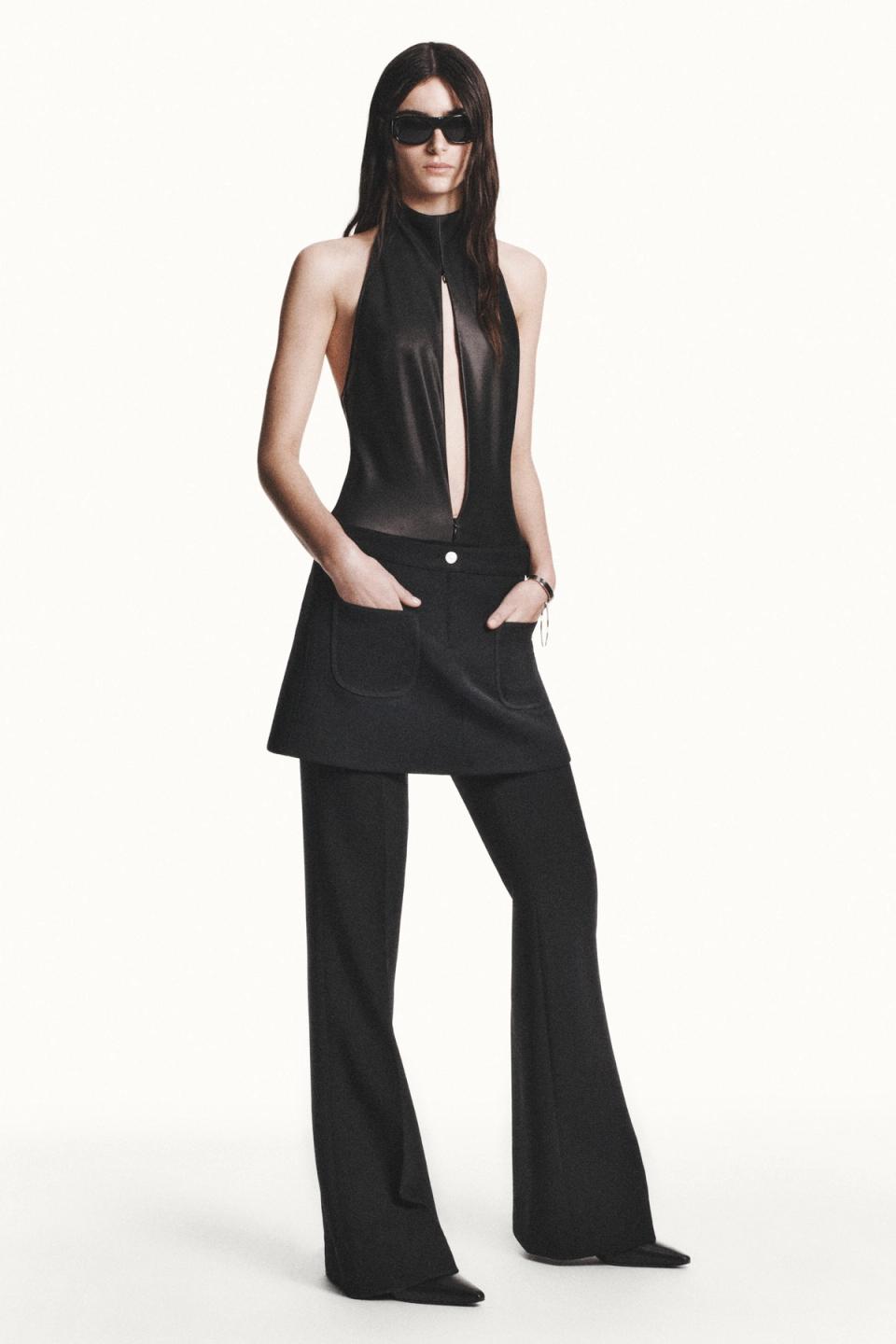 Elegant black leather dress with high collar, stylishly worn with sunglasses for Courrèges.