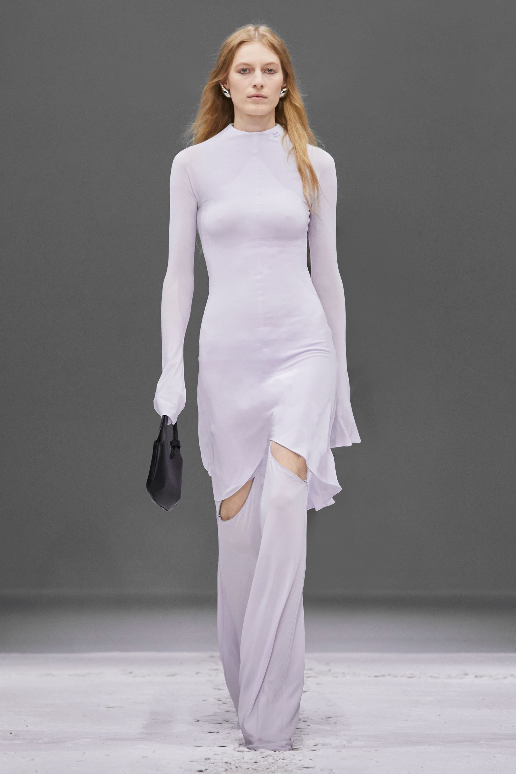 Elegant model in white Courrèges dress with cutouts, showcasing modern Parisian fashion.