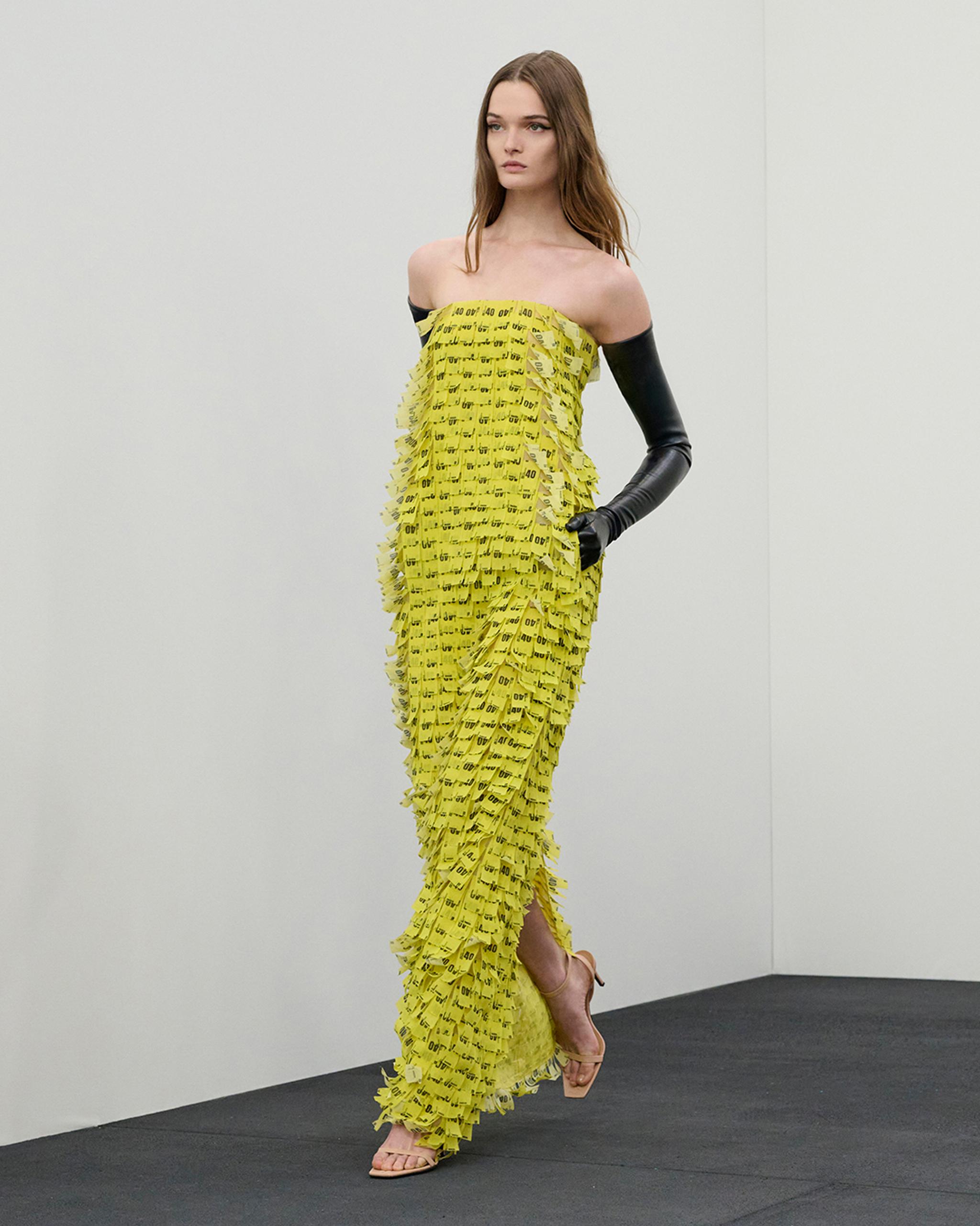 Fashion model wearing a yellow Courrèges dress made of layered ticket stubs for an ecommerce site.