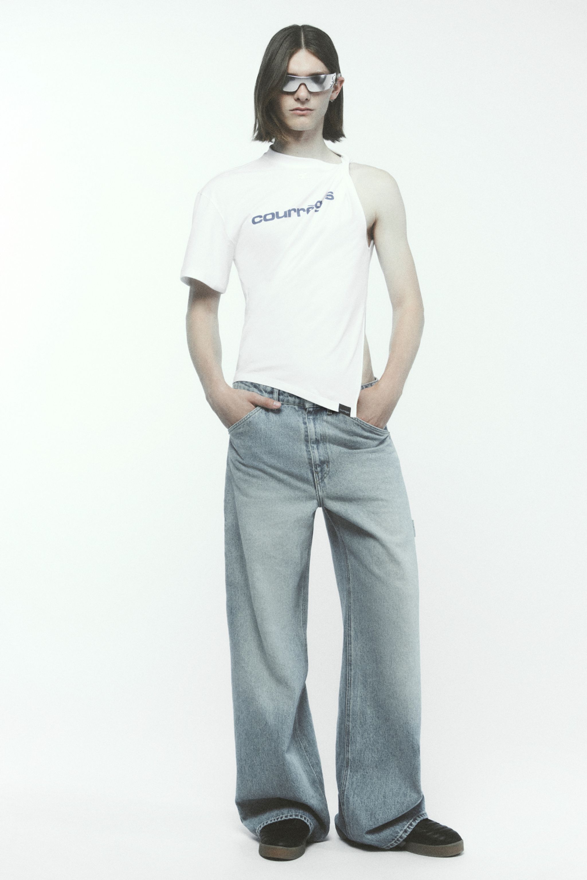 Fashion model wearing Courrèges T-shirt and oversized jeans, modern streetwear style for ecommerce.