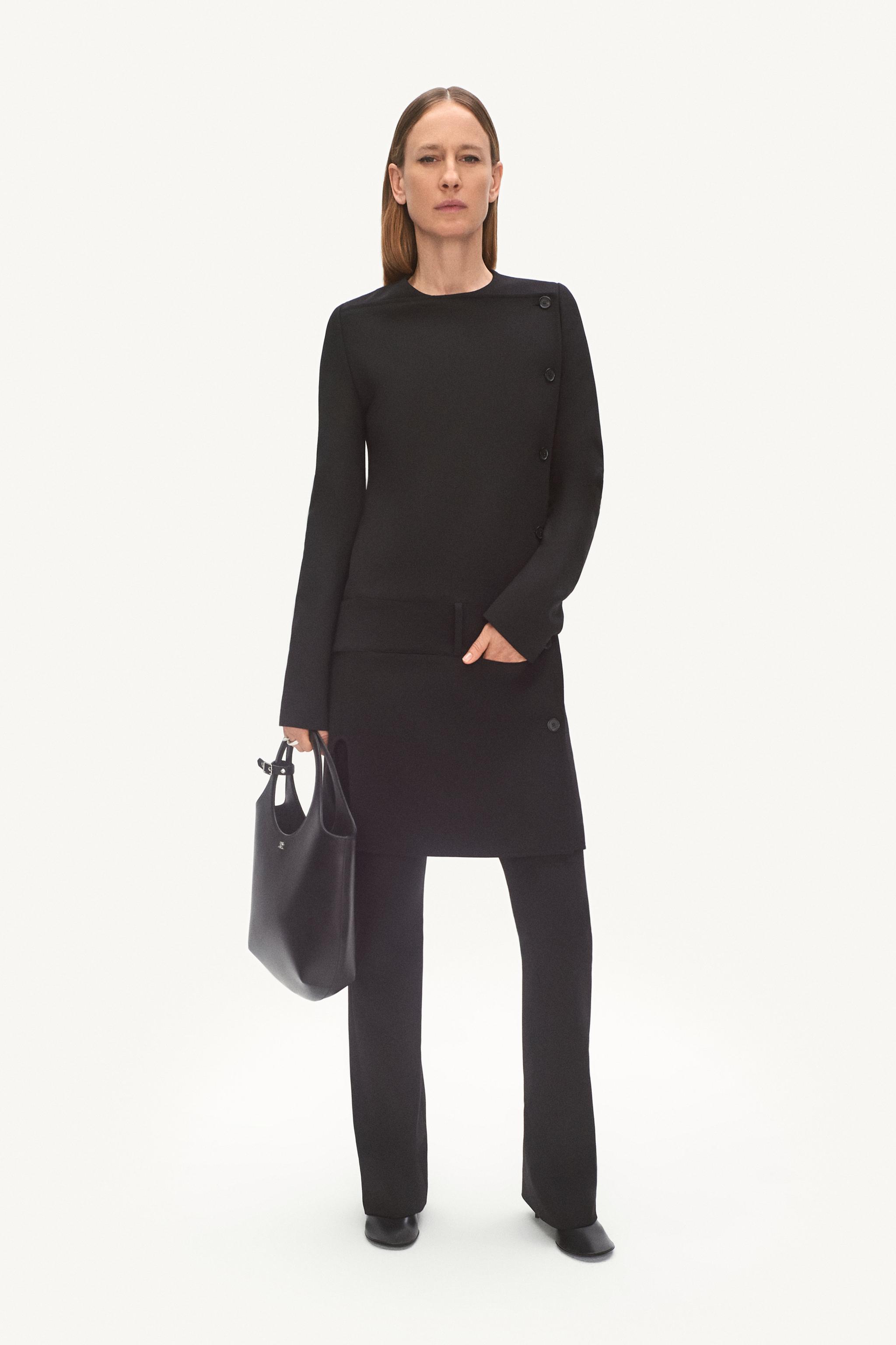 Elegant black Courrèges outfit featuring a tailored top, pants, and a tote bag for modern fashion.