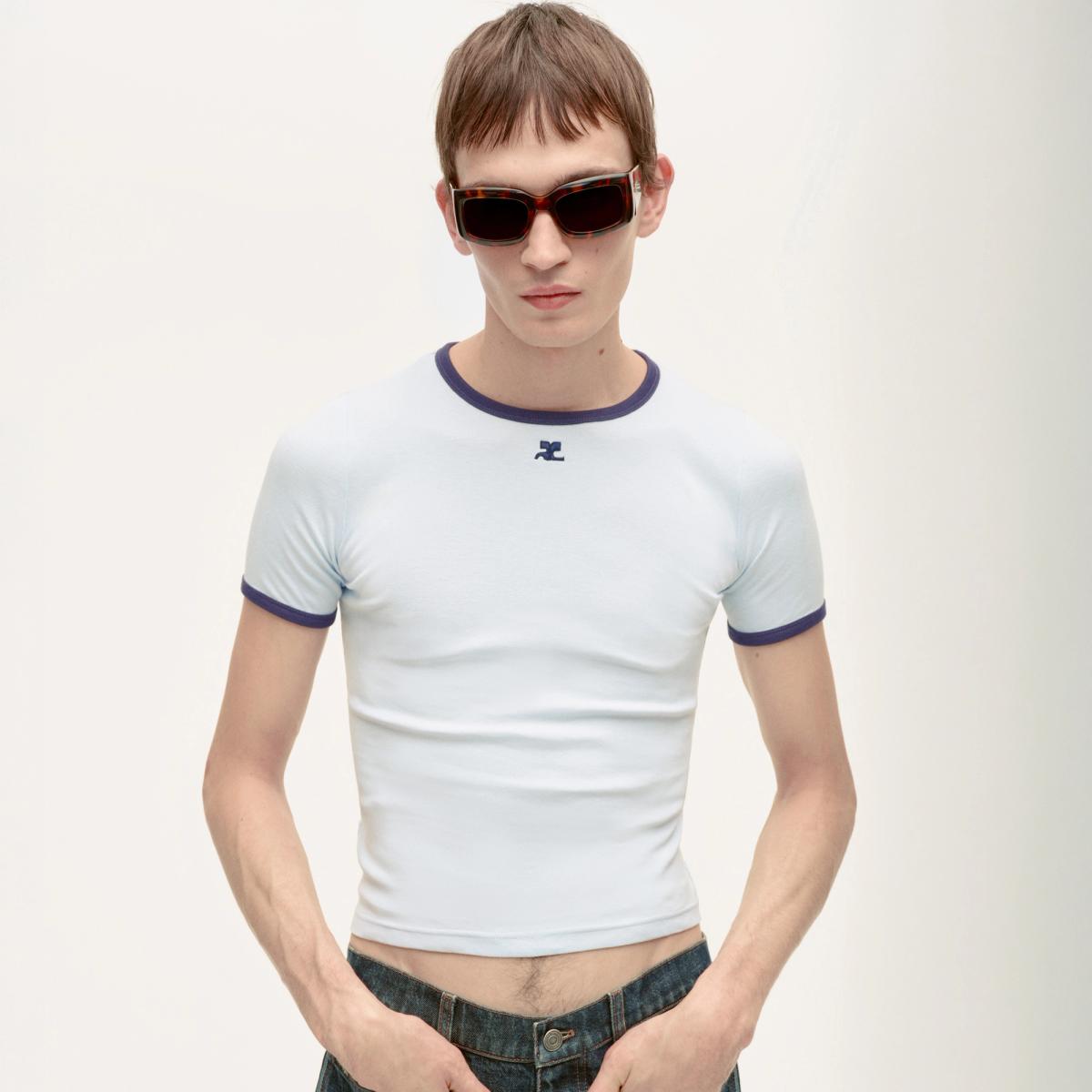 Elegant male model in casual Courrèges fashion with sunglasses on an e-commerce site.