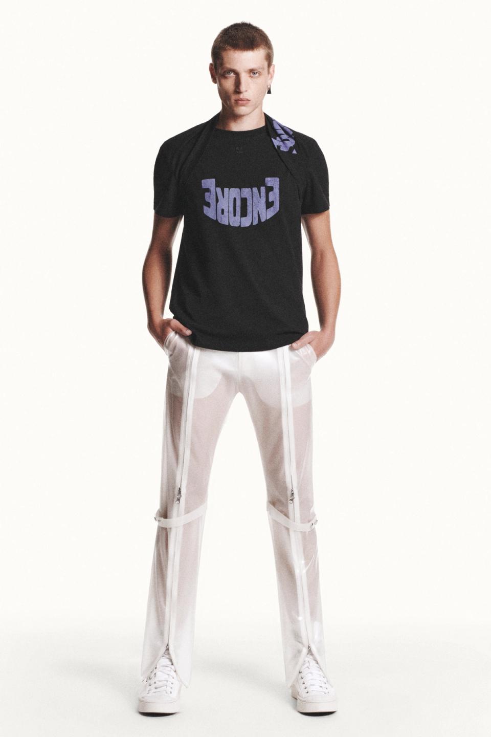 Fashionable male model wearing Courrèges streetwear with a graphic t-shirt and transparent pants.