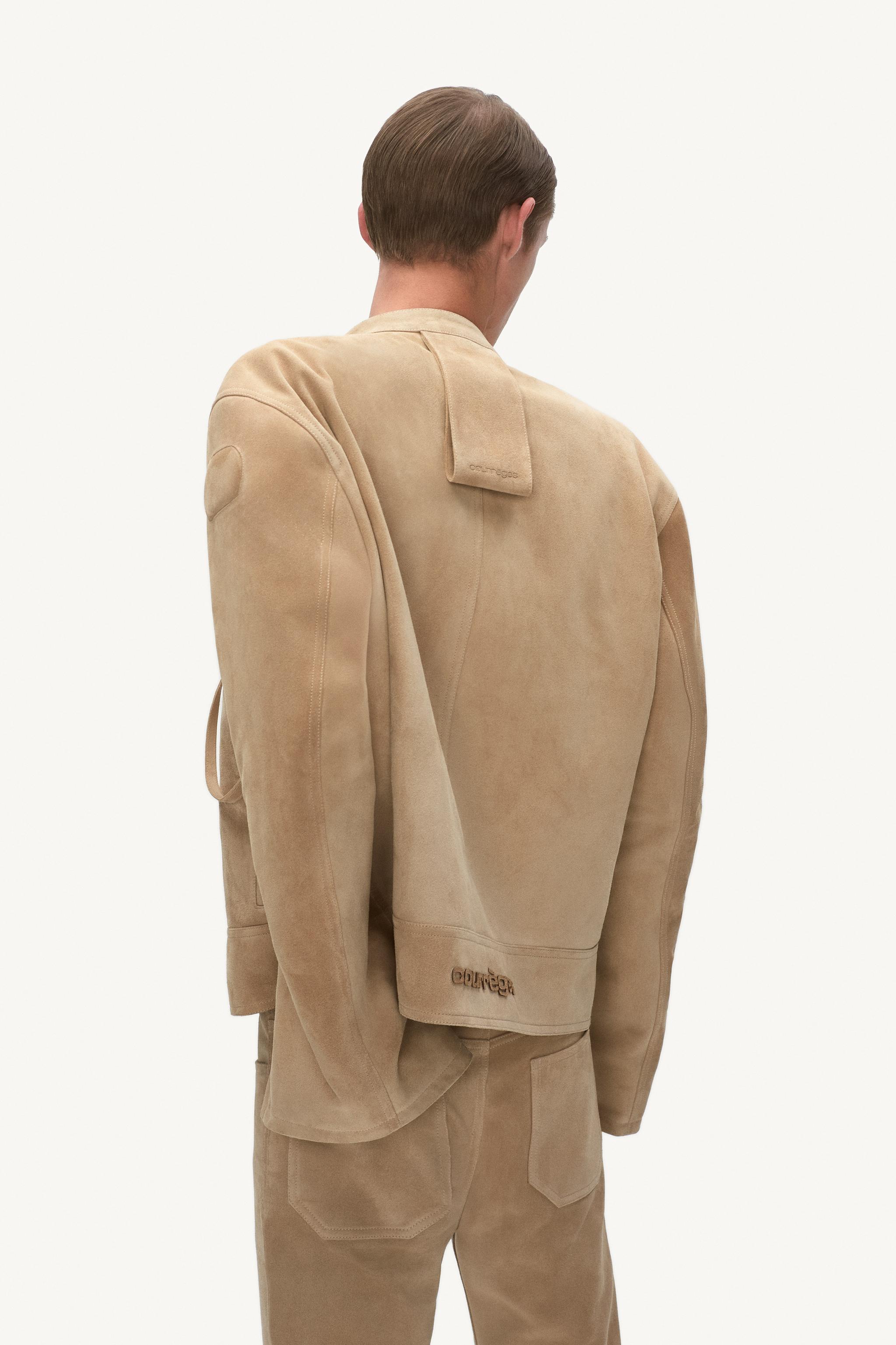 Elegant beige Courrèges jacket and pants displayed on a model for an ecommerce site.