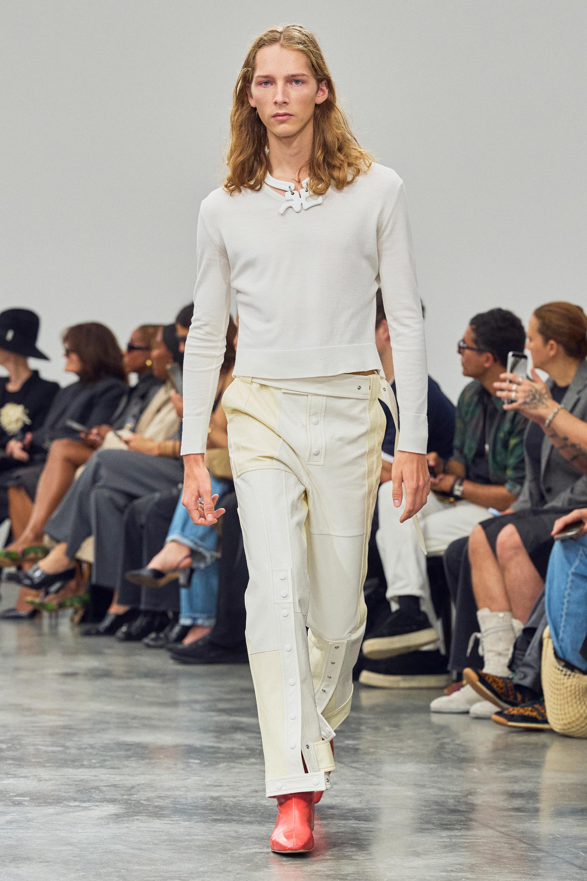 Elegant Courrèges fashion model walking runway in stylish white outfit for an ecommerce site.