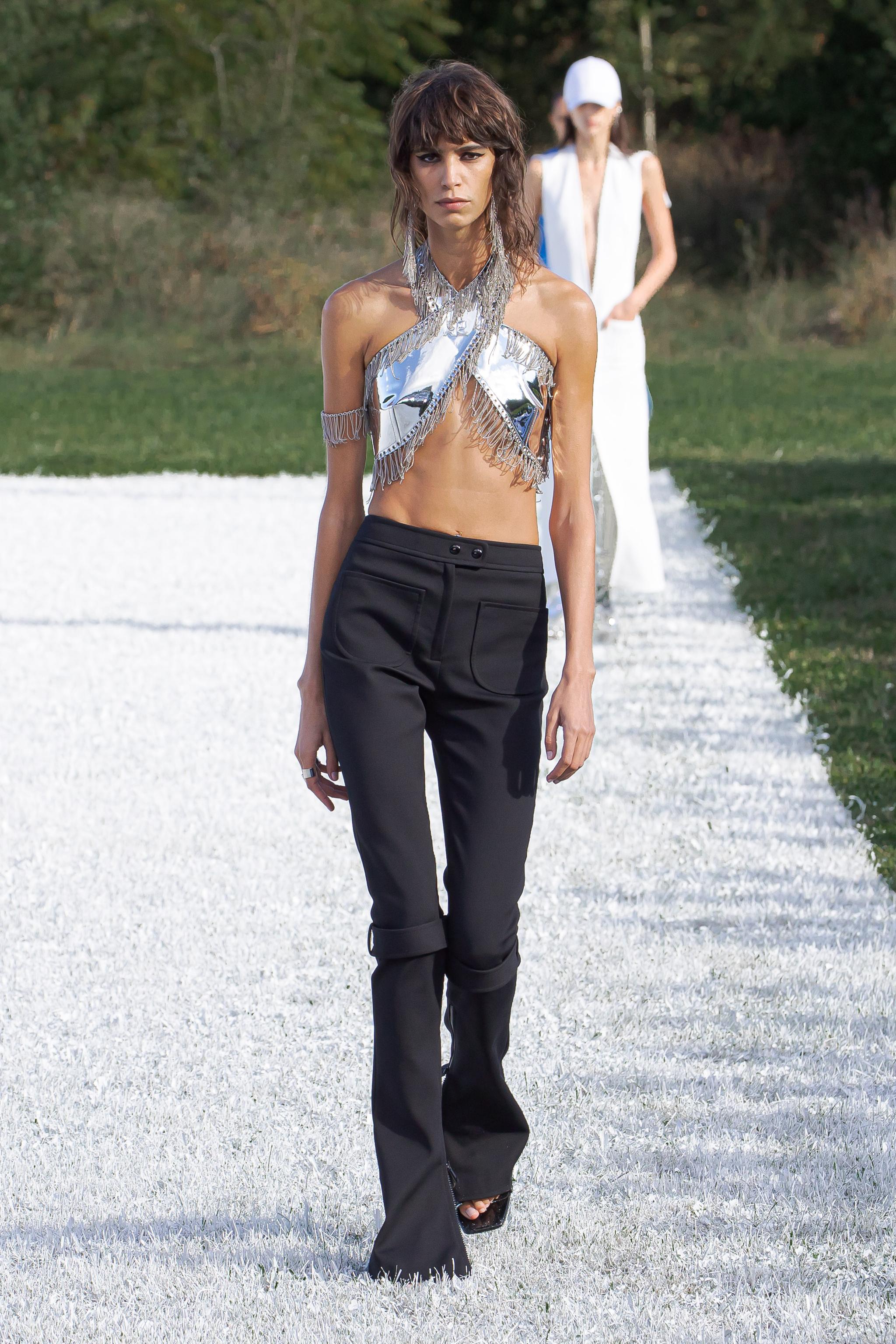 Chic runway look with metallic crop top and tailored black pants, by Courrèges.
