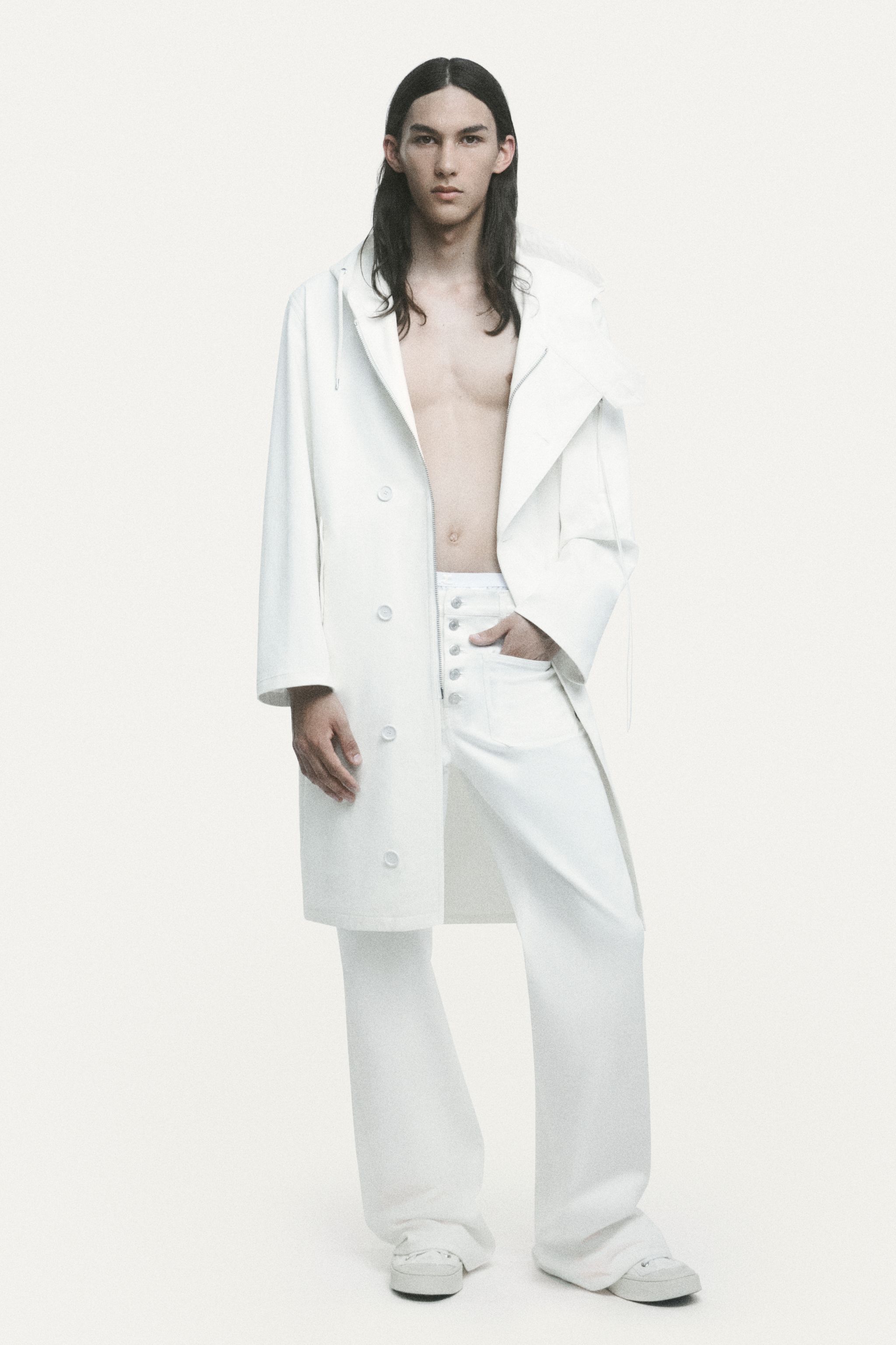 Elegant casual fashion featuring a white oversized sweater, layered with a denim skirt and wide-leg jeans, for Courrèges.