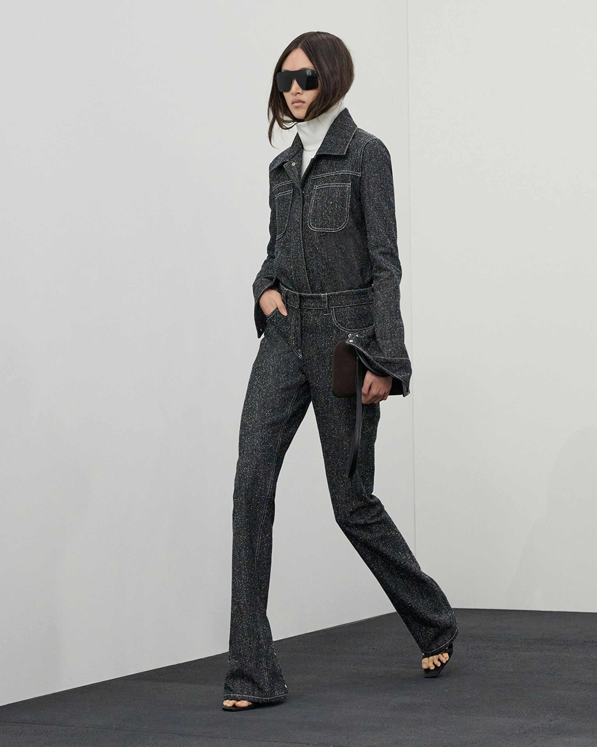 Tailleur en denim noir tacheté avec grandes lunettes de soleil, représentant la mode Courrèges.