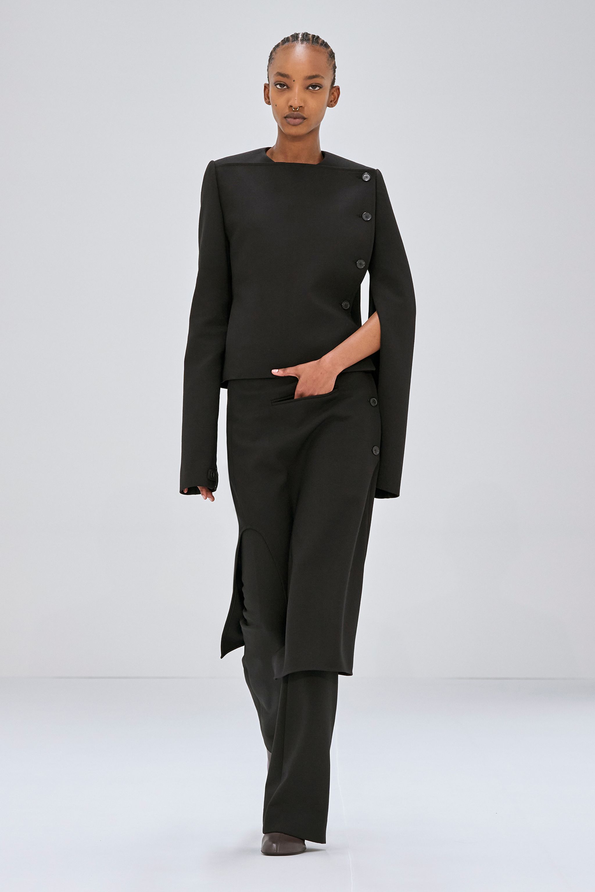 Elegant black tailored outerwear with asymmetrical button details, perfect for Courrèges fashion.