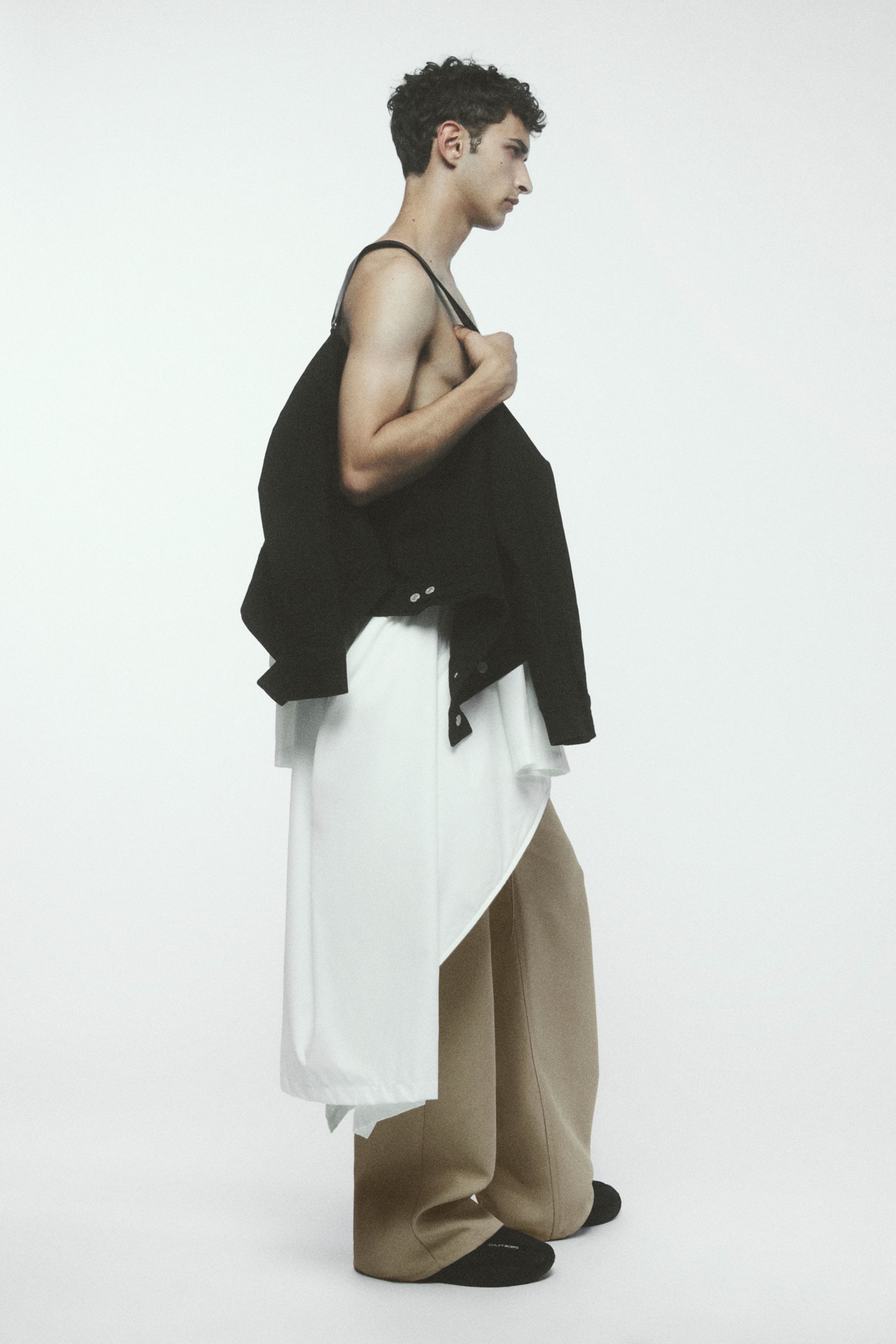 Elegant model wearing layered fashion pieces by Courrèges, showcasing modern style.