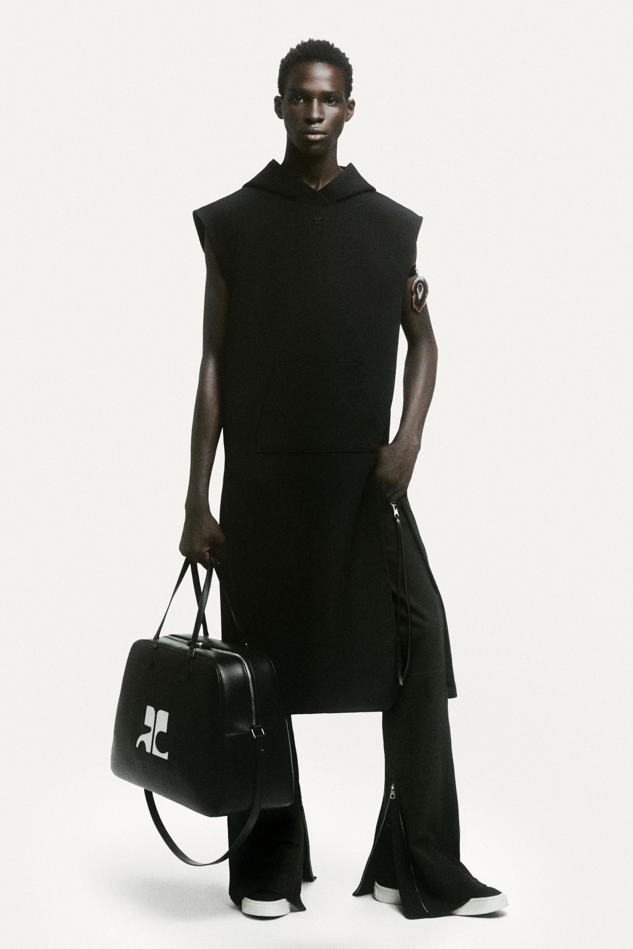 Elegant black sleeveless hoodie and wide-leg pants with a logo bag, Courrèges fashion style.