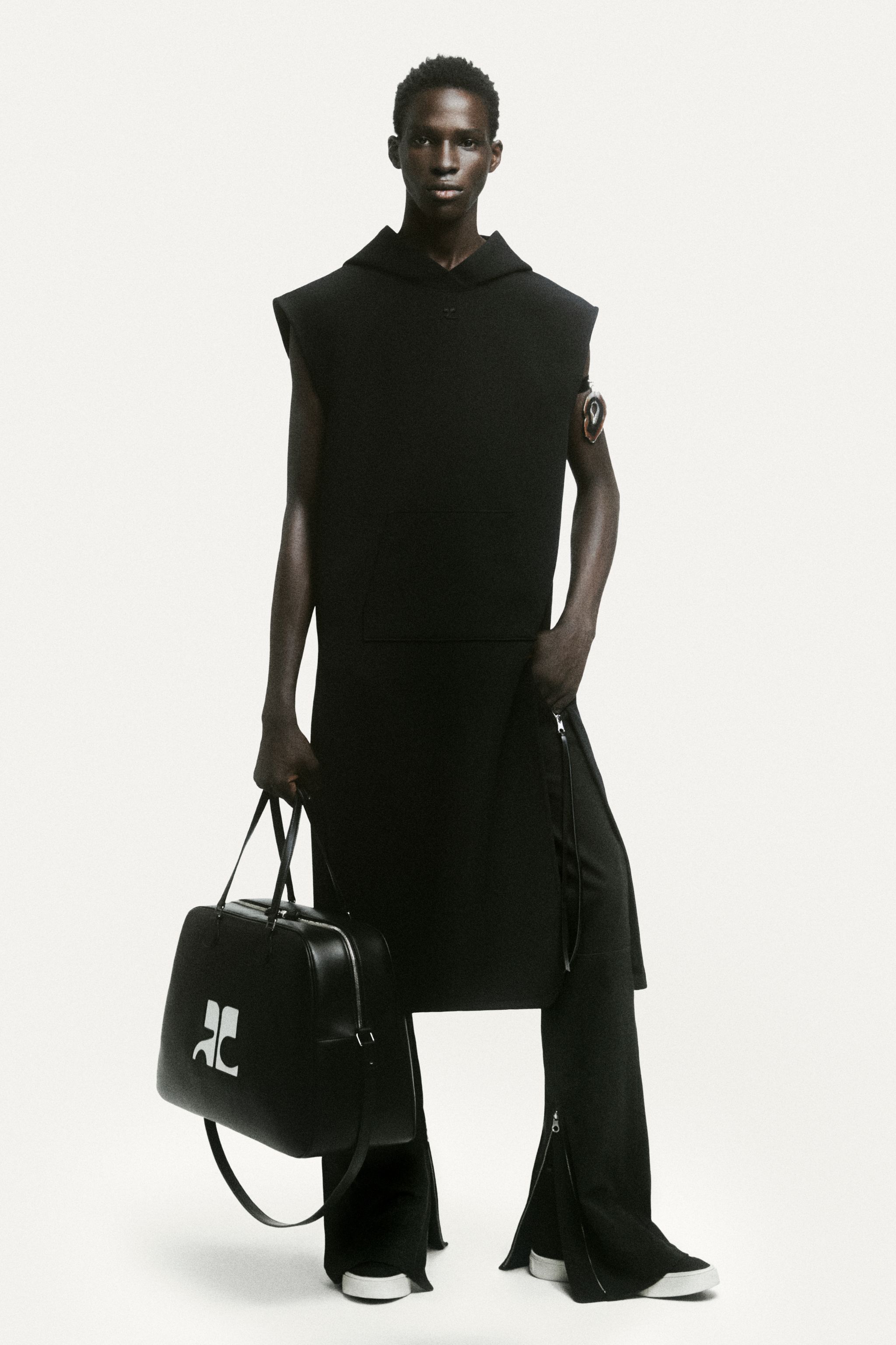 Elegant, modern black Courrèges outfit featuring a sleeveless dress, oversized hoodie, and accessories.