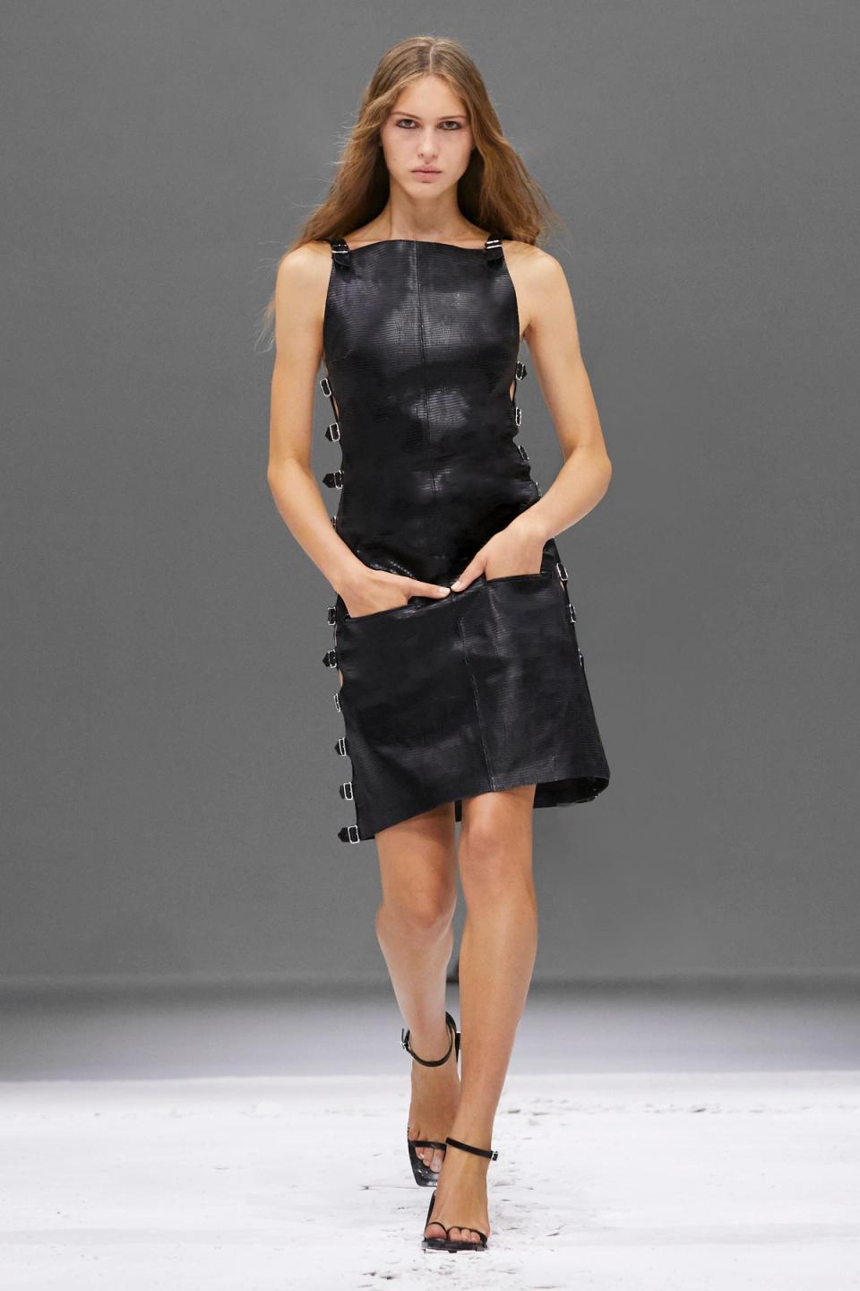 Elegant black dress with metal buckle accents, showcasing Courrèges' futuristic fashion style.