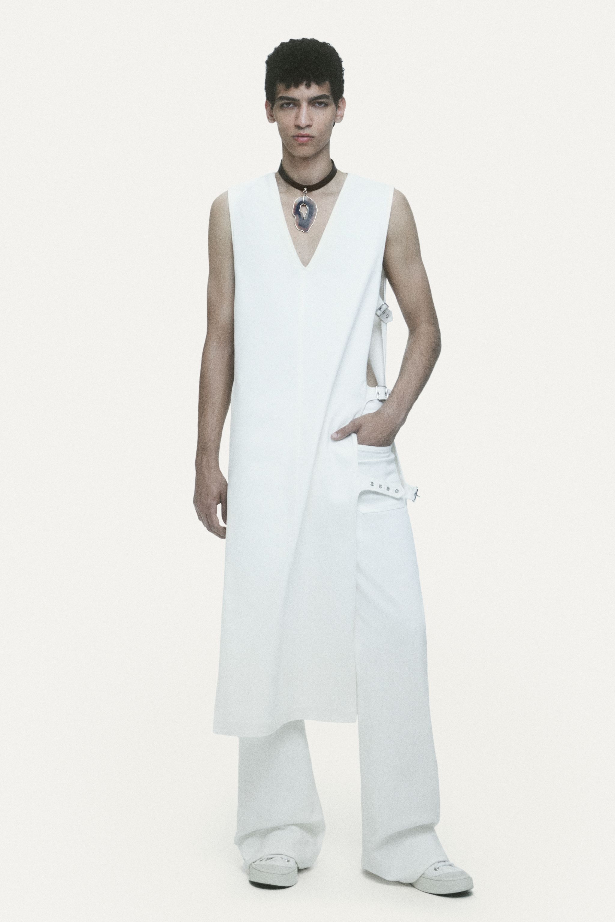 Model in white modern fashion outfit showcasing Courrèges' sleek futuristic style.