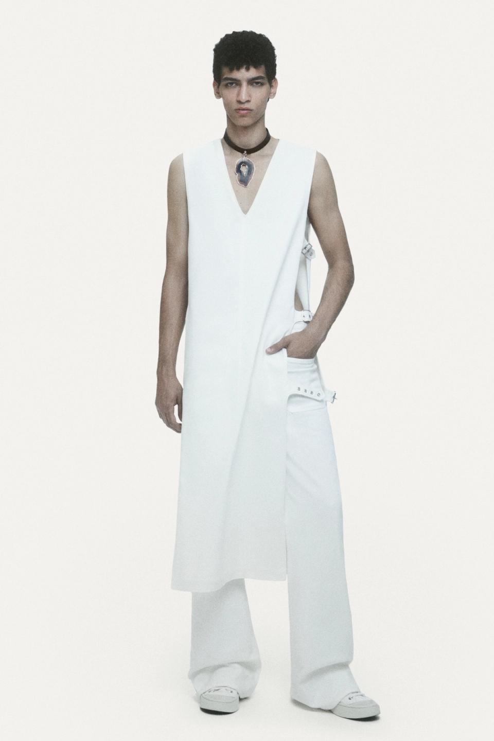 Model in white modern fashion outfit showcasing Courrèges' sleek futuristic style.